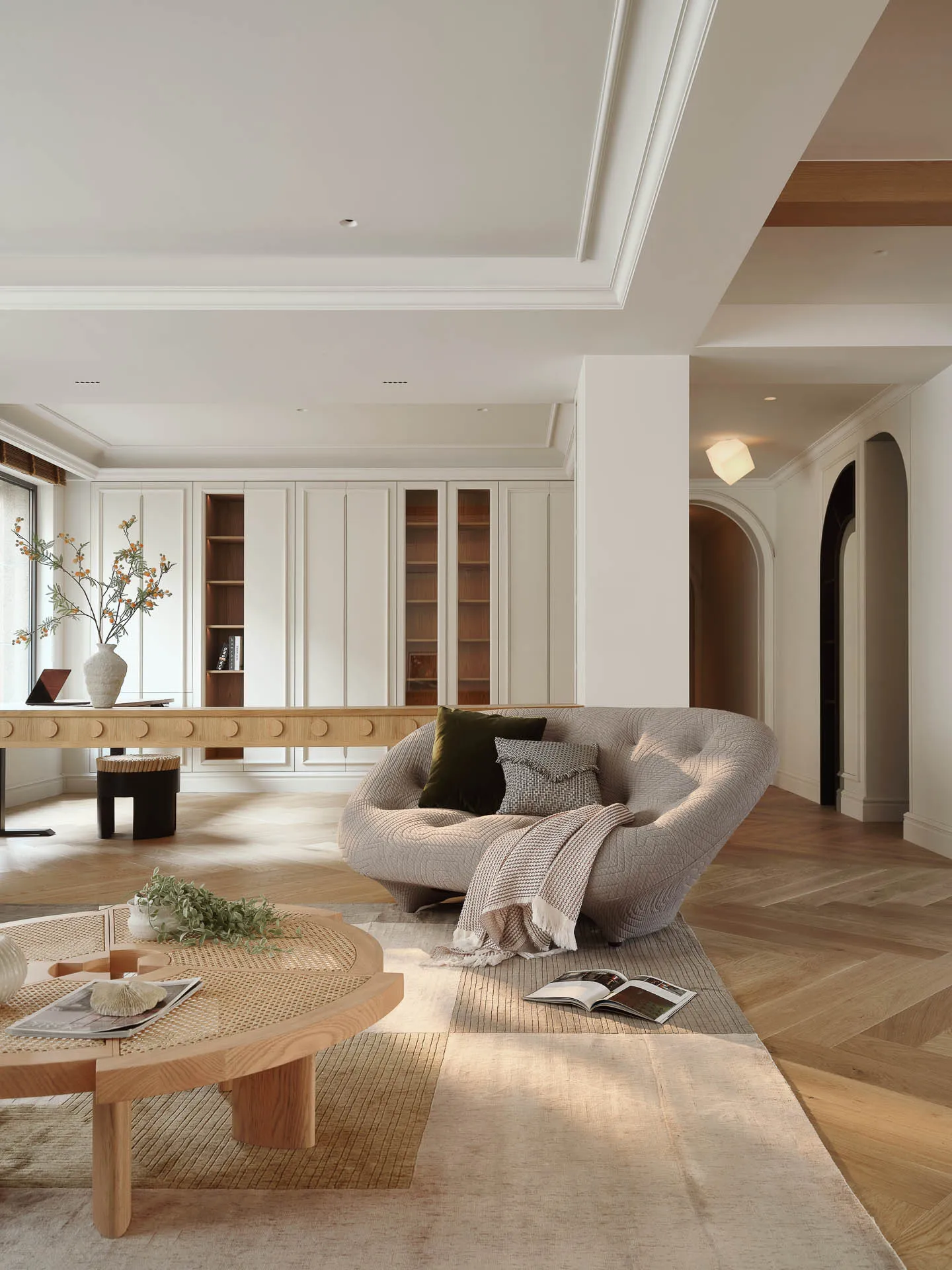 A modern living room with a Scandinavian design featuring a curved sofa, wooden coffee table, and bookcase.