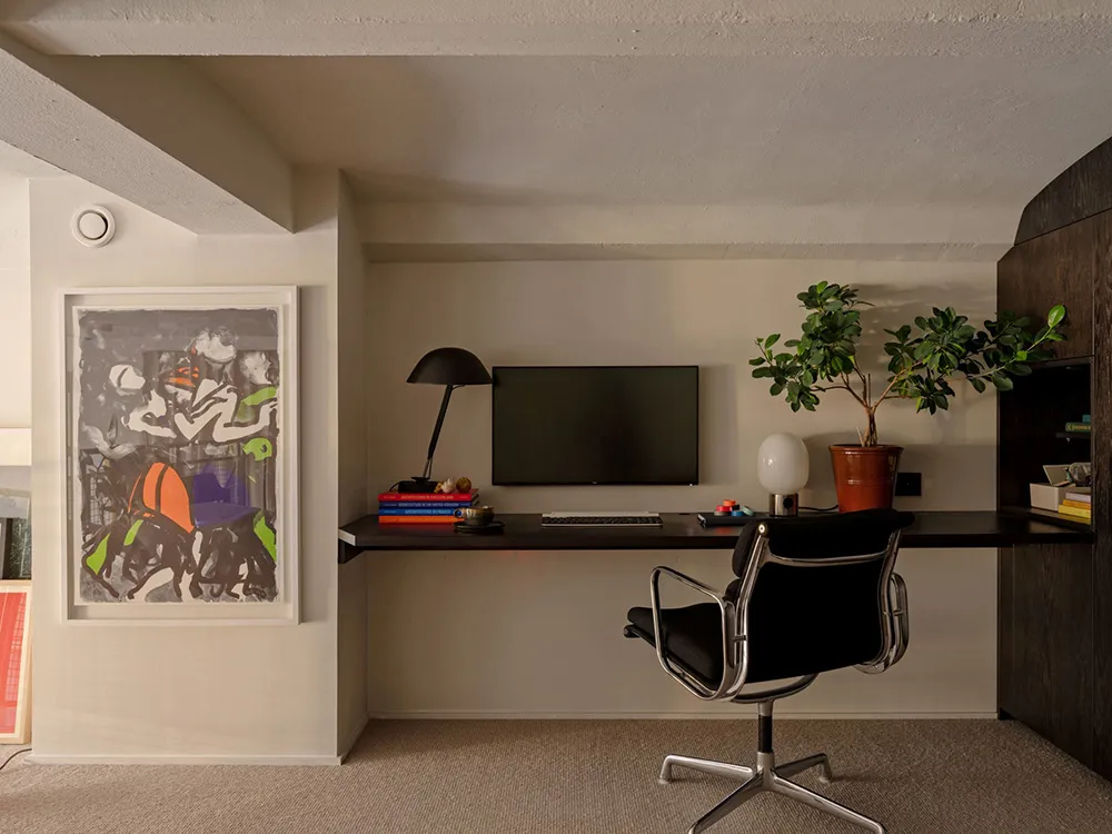 An industrial-style workspace featuring black office furniture, a white backdrop, and minimalist decor.