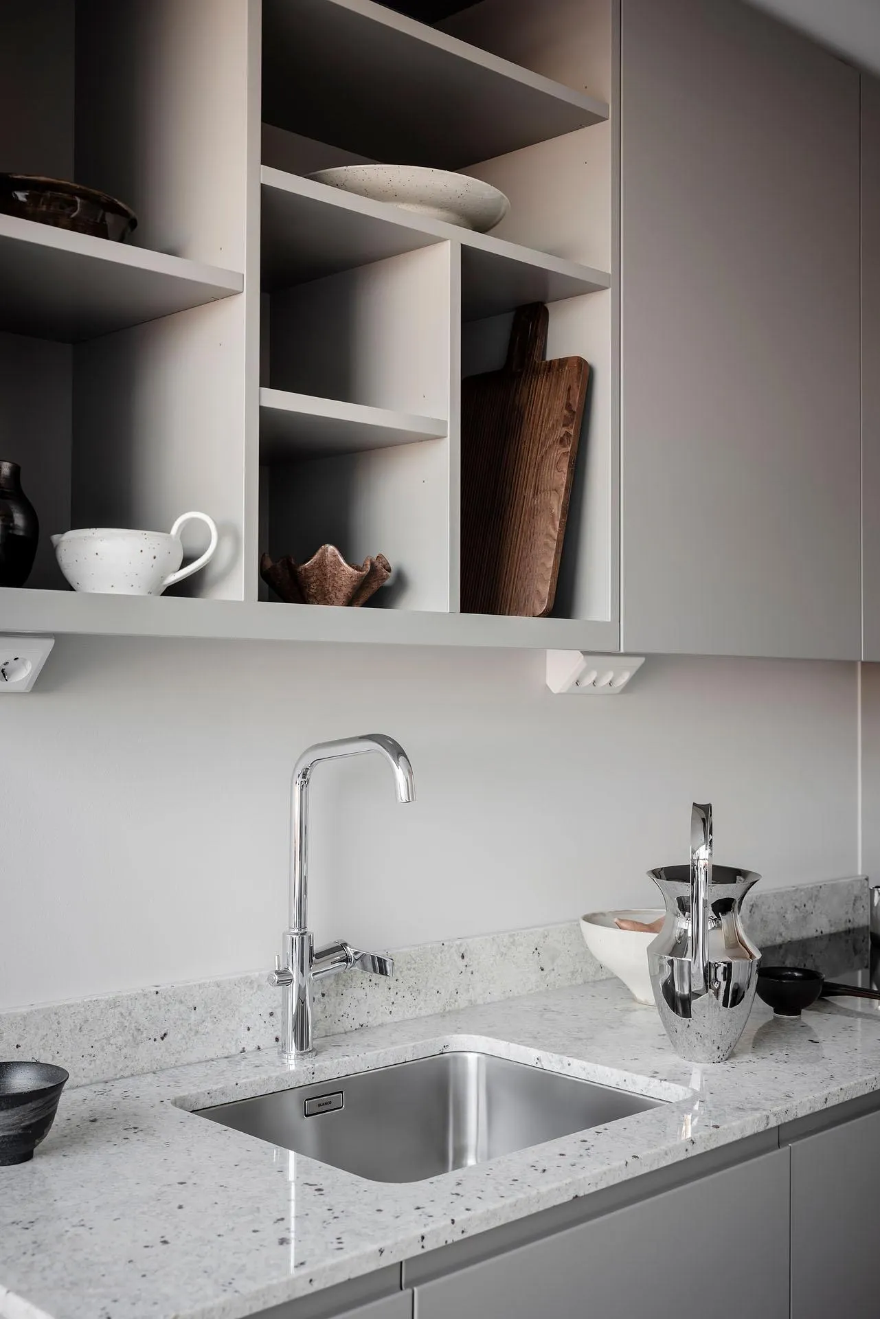 A modern, minimalist kitchen featuring a concrete countertop, designed for functionality and aesthetic appeal.