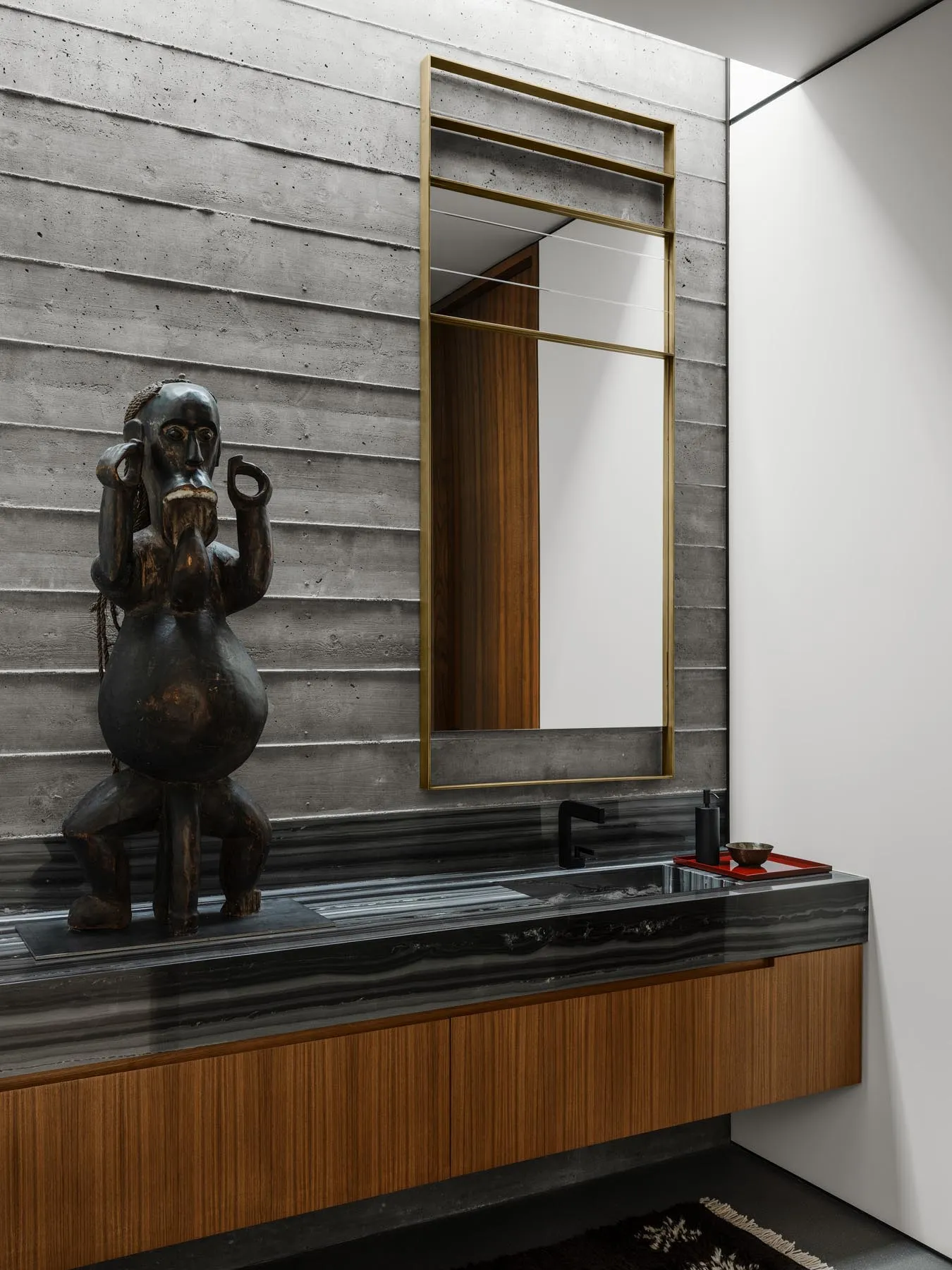 Modern industrial bathroom with concrete walls, black marble countertops, and wood accents.