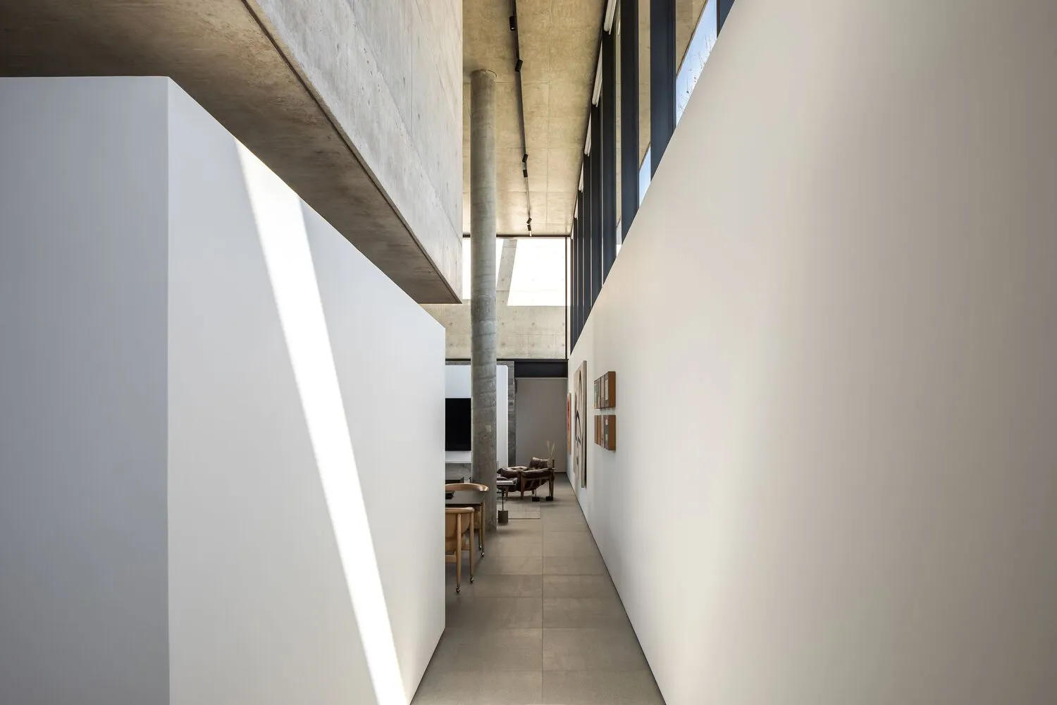 Modern architectural space with minimalist design, concrete walls, and large windows.