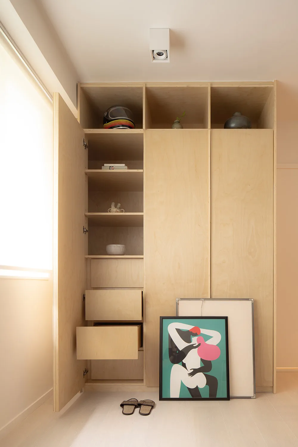 Modern wooden wardrobe storage unit with open shelves and closed compartments.