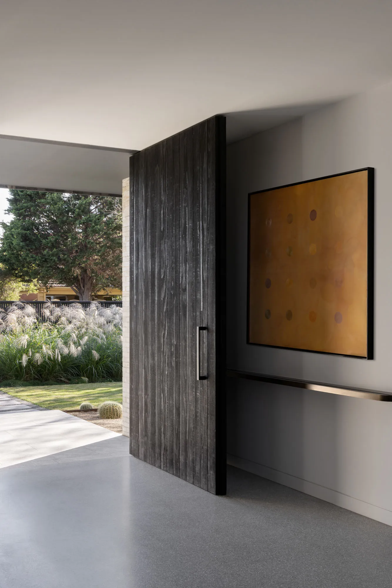 Modern industrial-style front door with a concrete base and wooden paneling in a residential entrance.