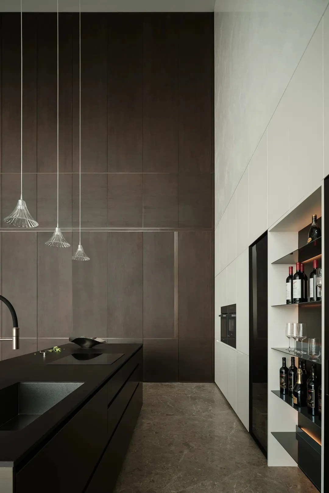 A modern, minimalist kitchen with marble countertops and white cabinets.