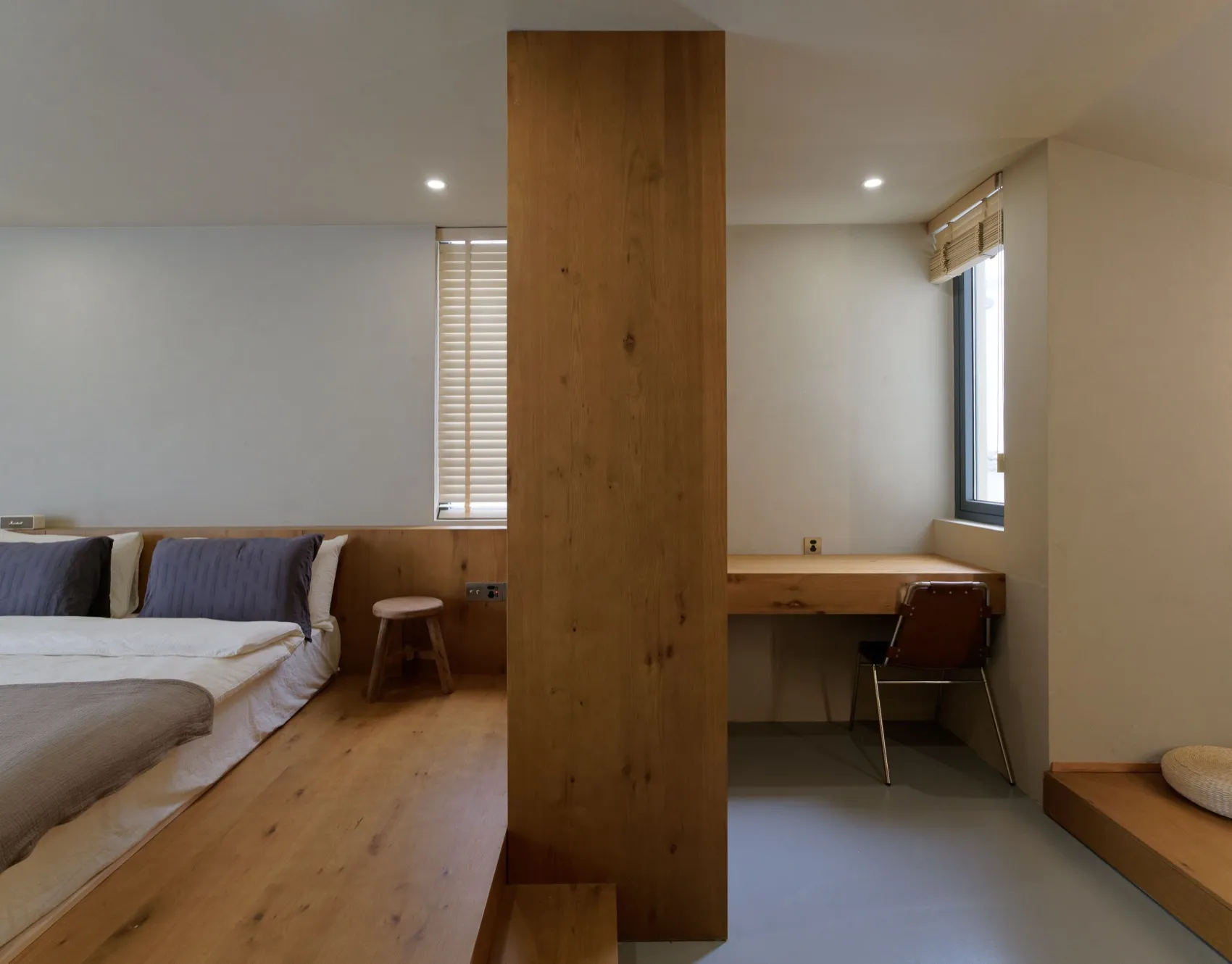 Modern bedroom with wooden flooring and minimalist design.