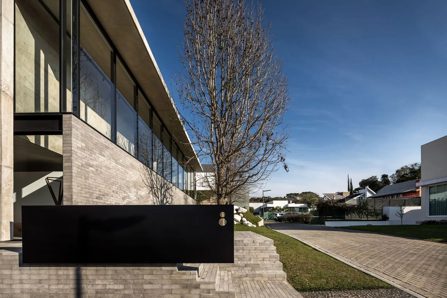 Modern building exterior with large glass windows and concrete structure.