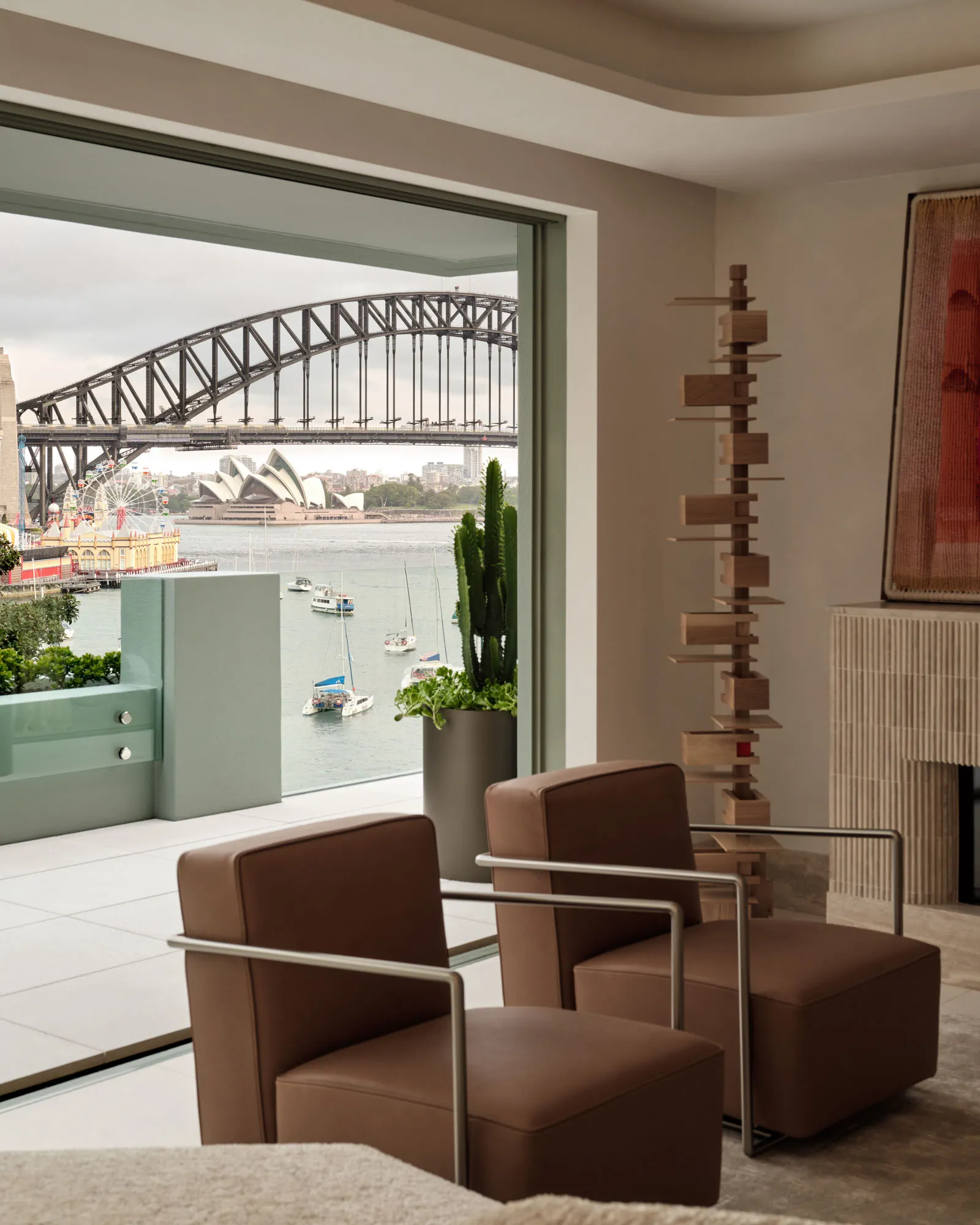 Contemporary living room with modern furniture, a cactus plant, and a view of the Sydney Opera House and Harbour Bridge acros