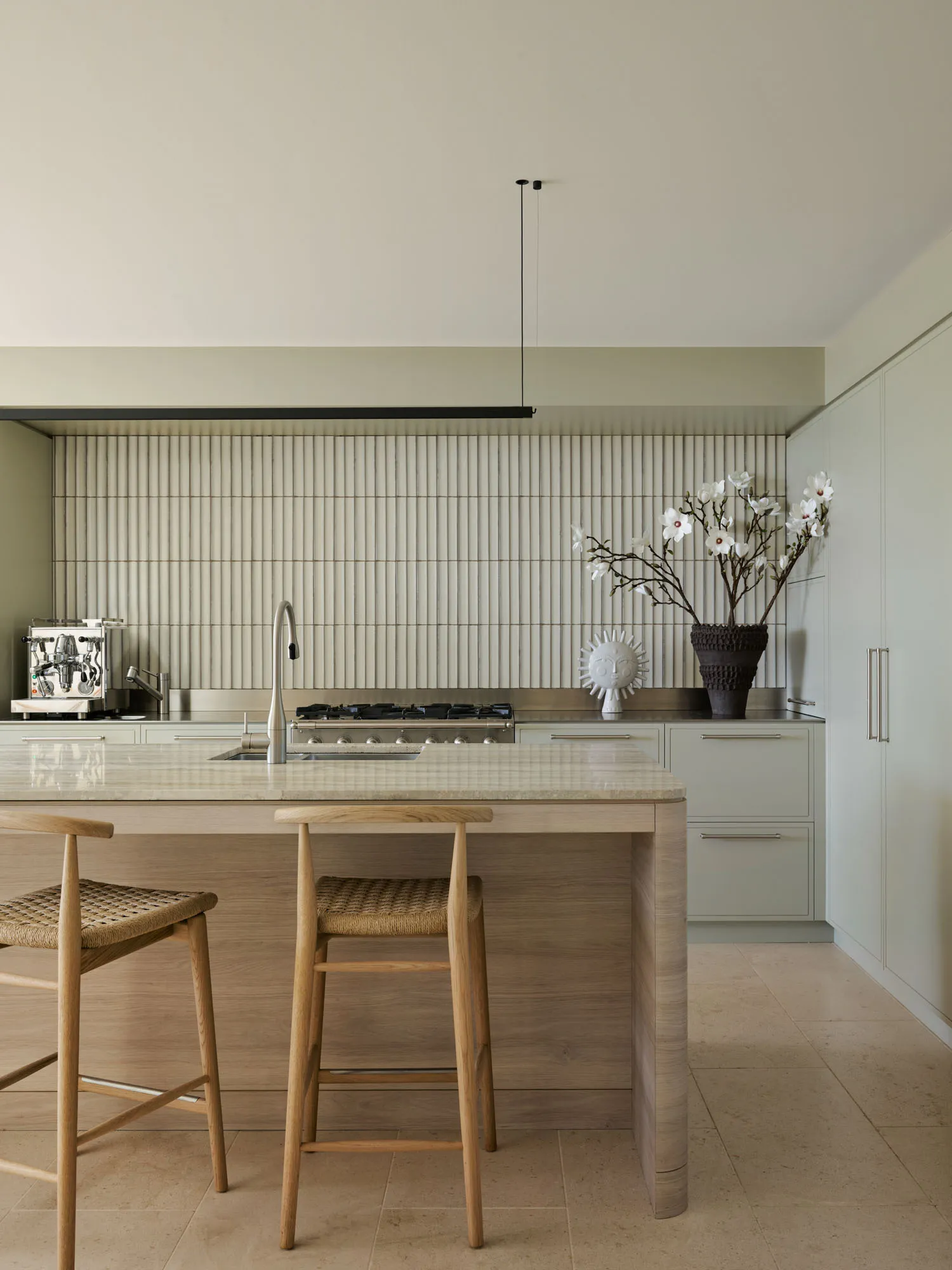 Modern kitchen featuring metallic tiles, wooden cabinets, and a marble countertop.