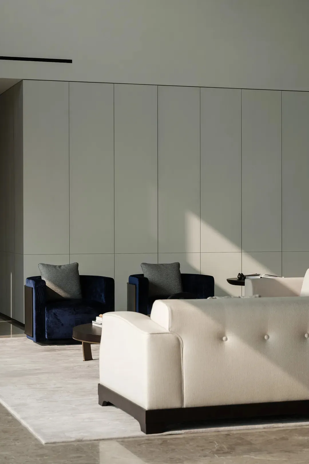 Interior design featuring a modern minimalist living room with fabric furniture and a white sofa.