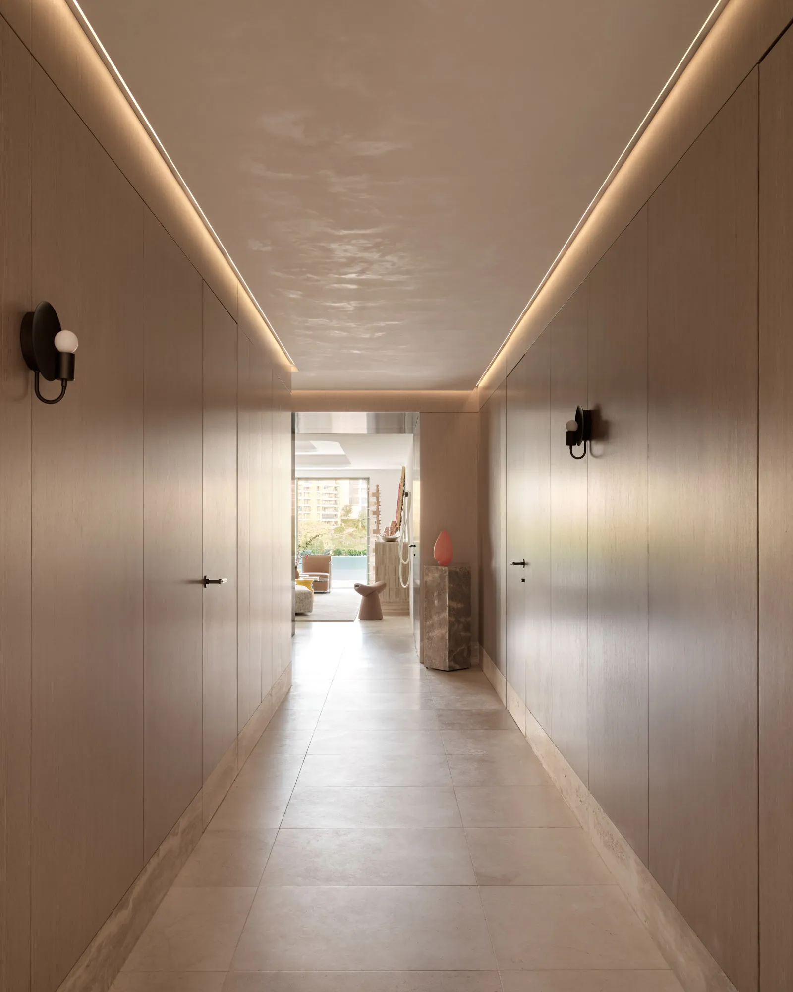 A modern interior of a corridor featuring concrete flooring and minimalist design elements.