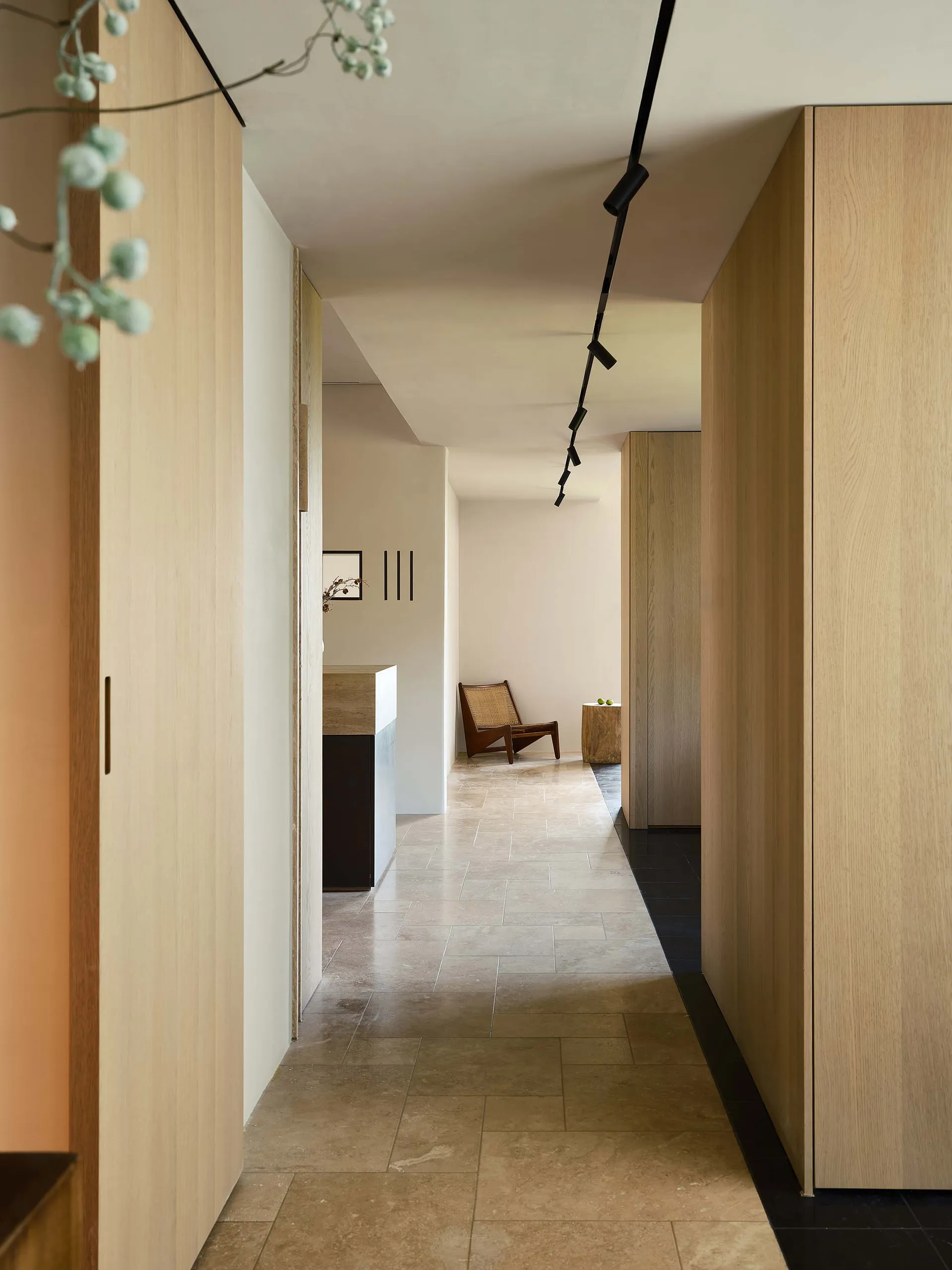 A modern corridor with wooden walls and a tiled floor.