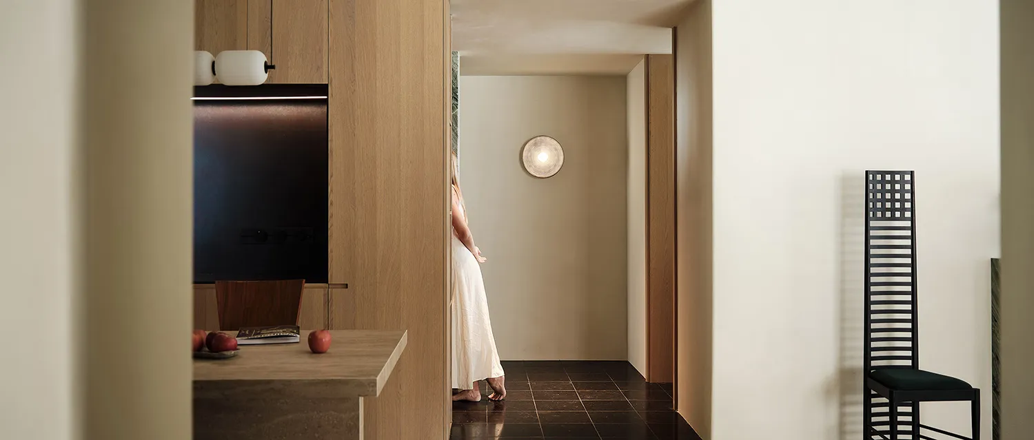 A sleek, modern entryway designed with wooden panels and stone flooring.