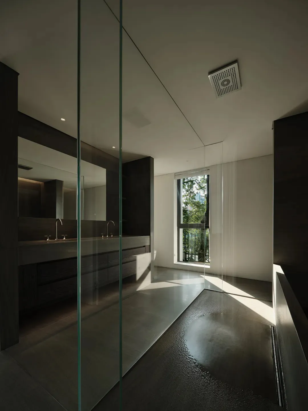 Minimalist modern bathroom with a concrete floor and glass shower enclosure.