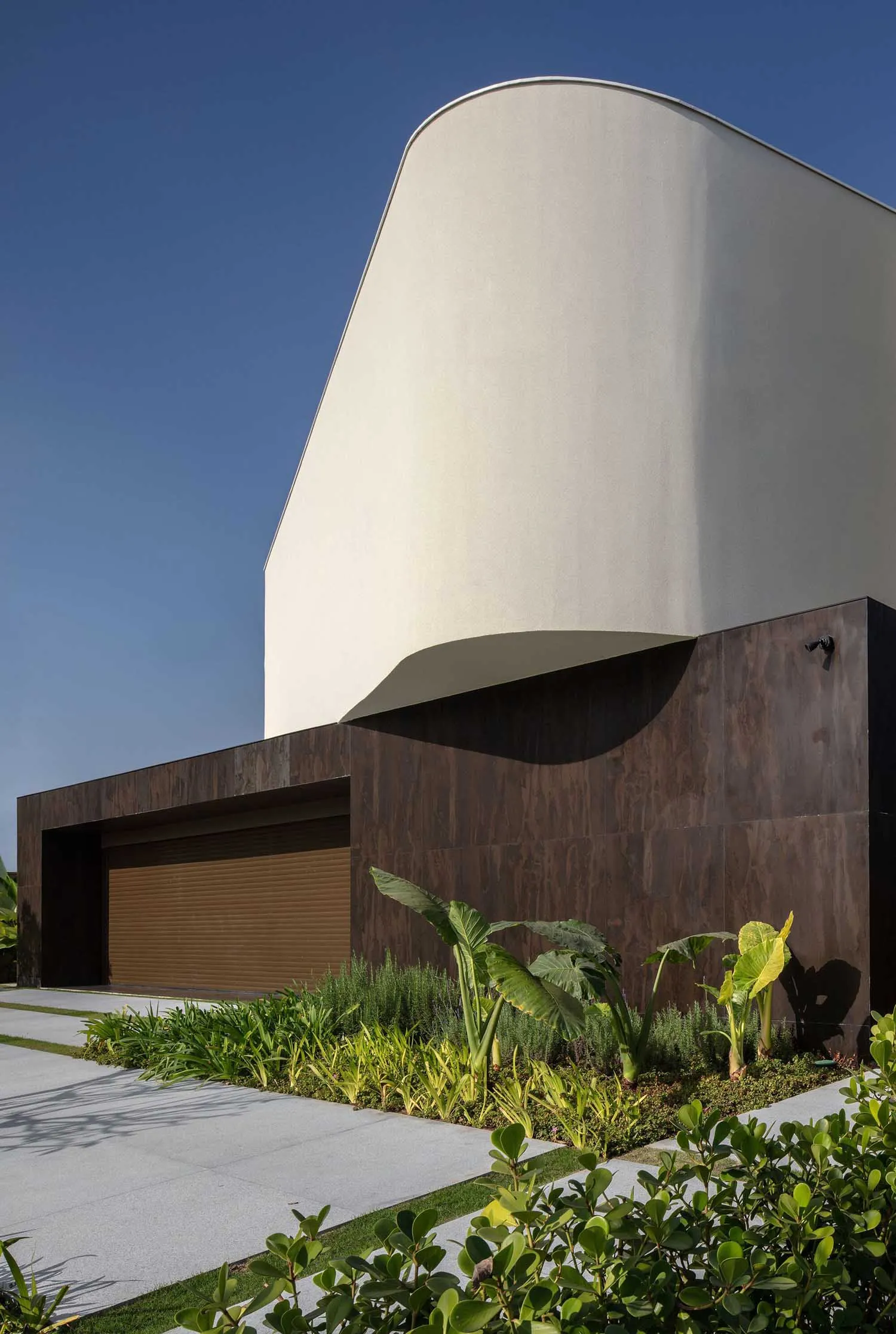 Concrete exterior of a modern house with curved roof and minimalist design.
