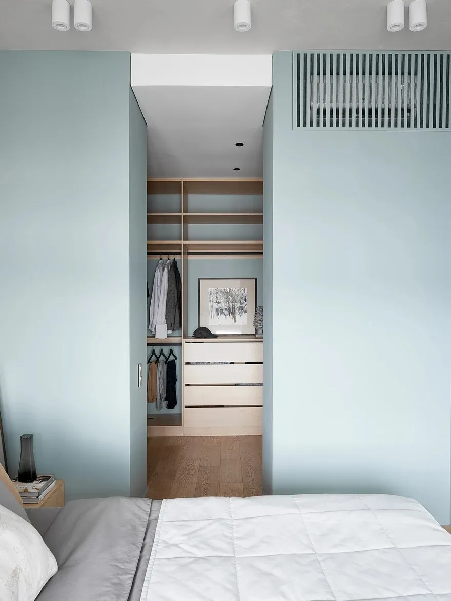 Modern minimalist bedroom featuring wood storage solutions.