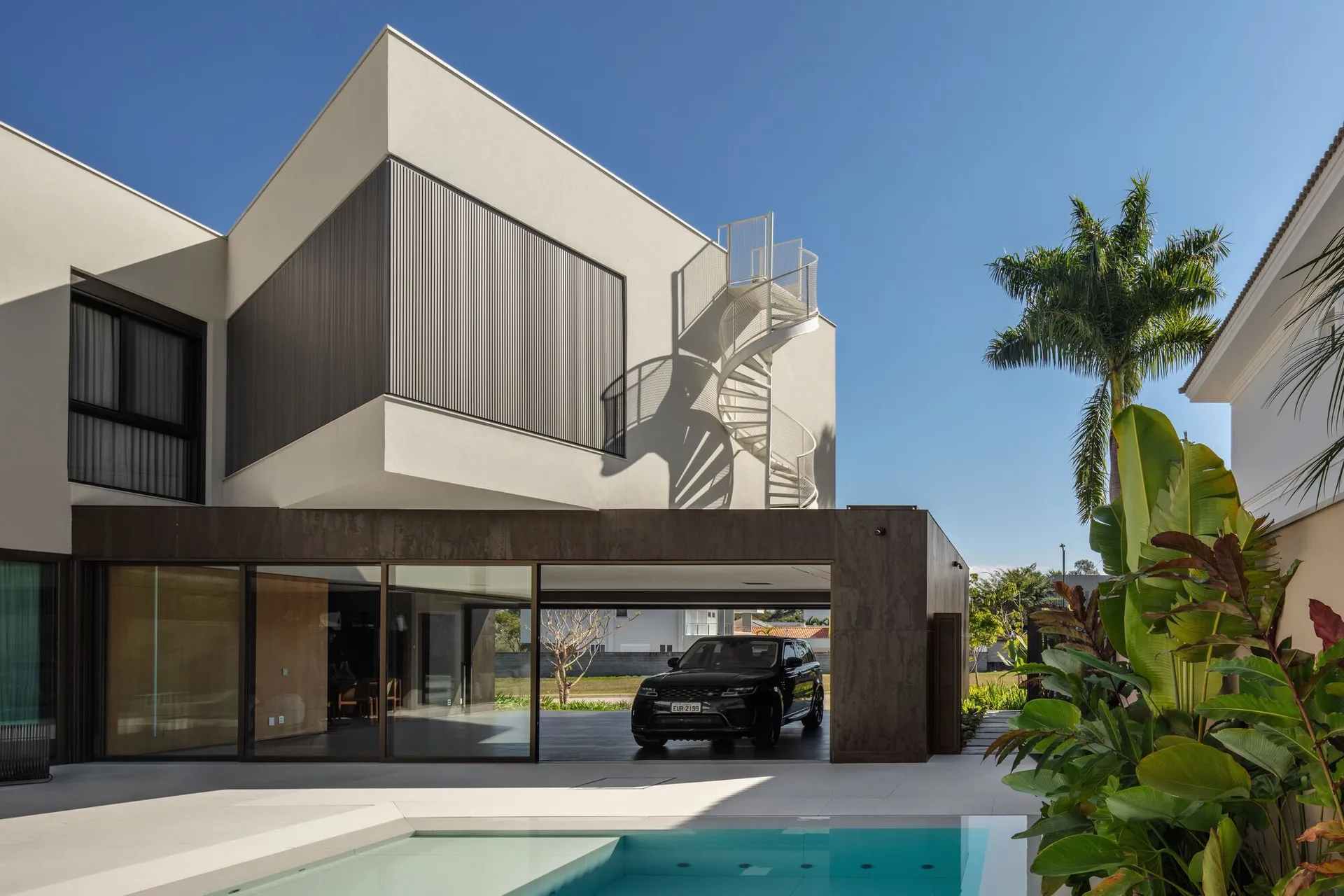 A modern residential building featuring concrete and glass materials.