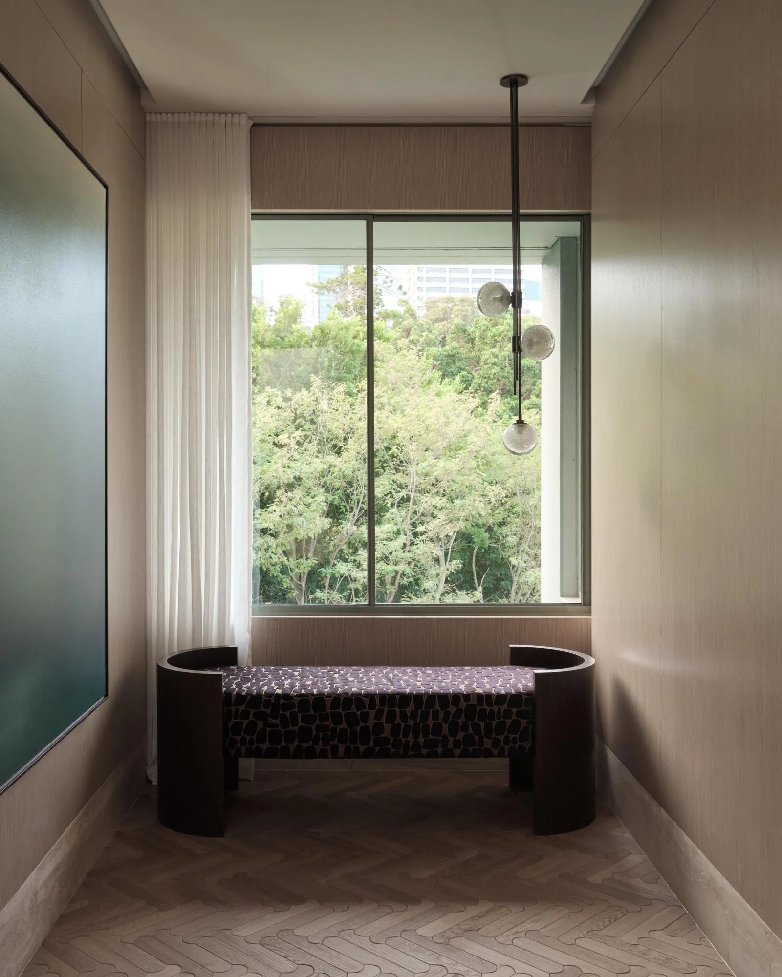 Modern living room with a comfortable window seat upholstered in wood-textured fabric, featuring a minimalist design and natu