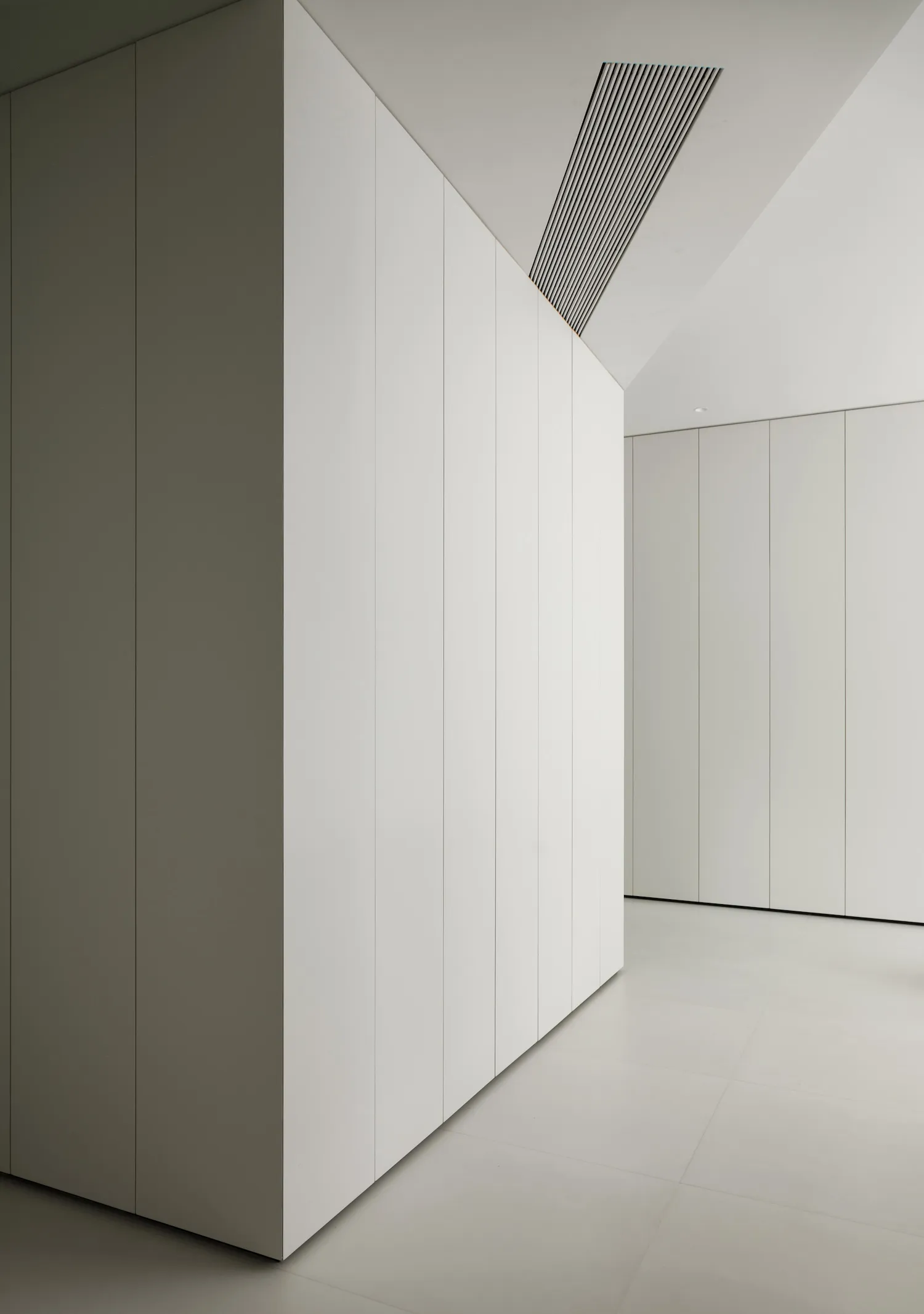 A minimalist interior space with white panels covering the walls.