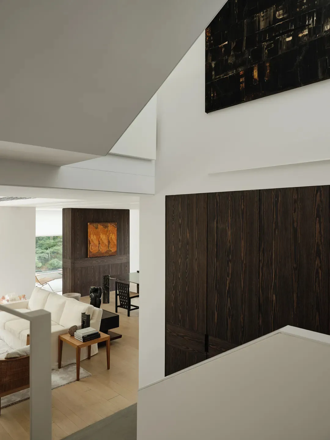 Modern interior design featuring a living room with dark wood decor and a white sofa.