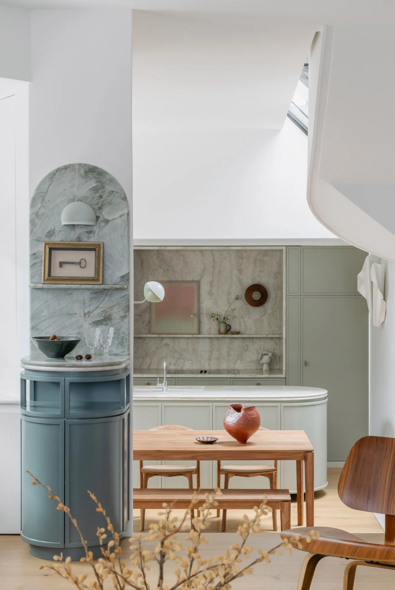 Modern living, dining, and kitchen space featuring marble countertops, wooden furniture, and ceramic ornaments.