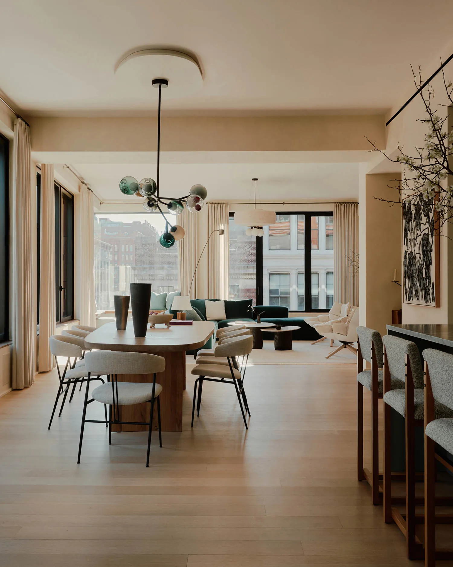 Modern living room with wood flooring, fabric furniture, glass elements, and metal accents.