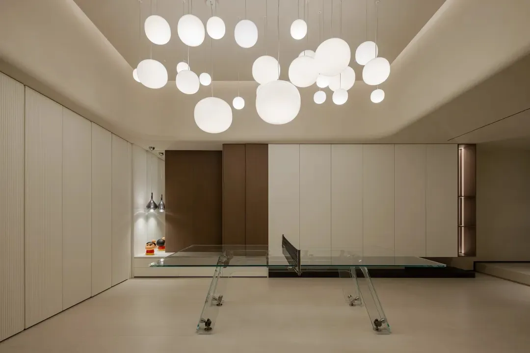 A modern, minimalist living room with a glass table.