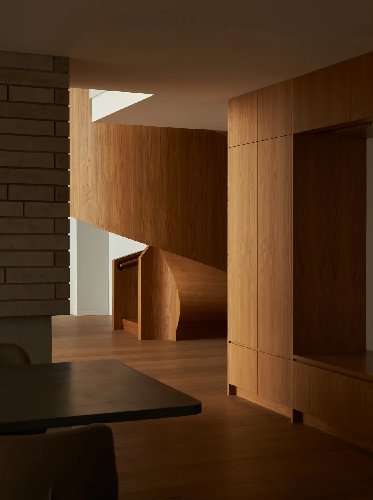 Modern residential interior with wooden elements and a spiral staircase.