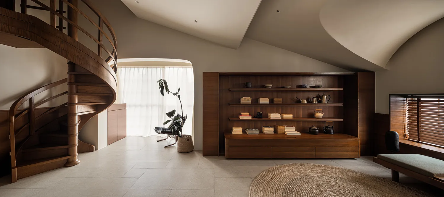 A modern residential library featuring wooden shelves and furniture.