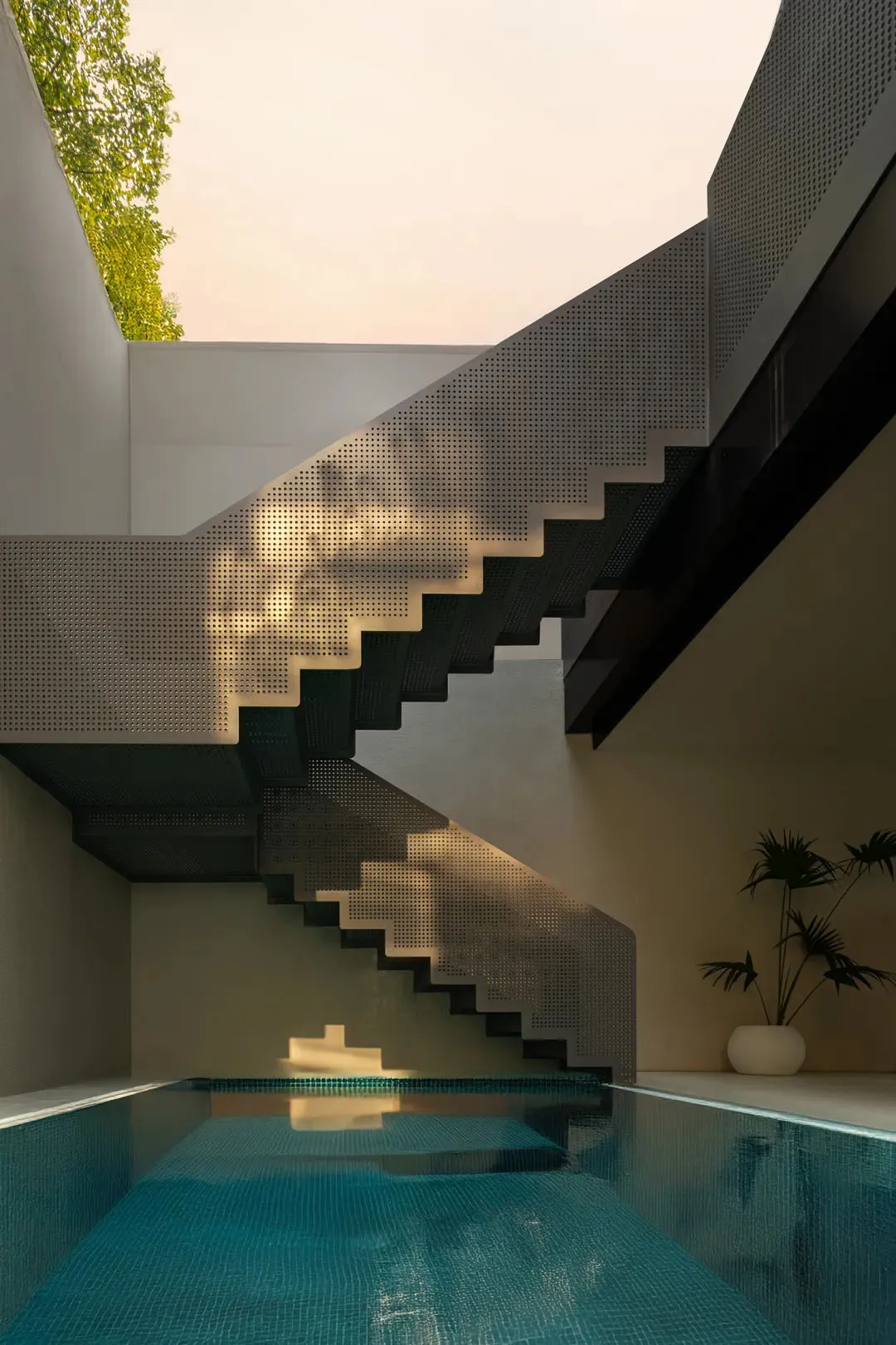 Concrete stairs with perforated metal tread in a modern interior setting.