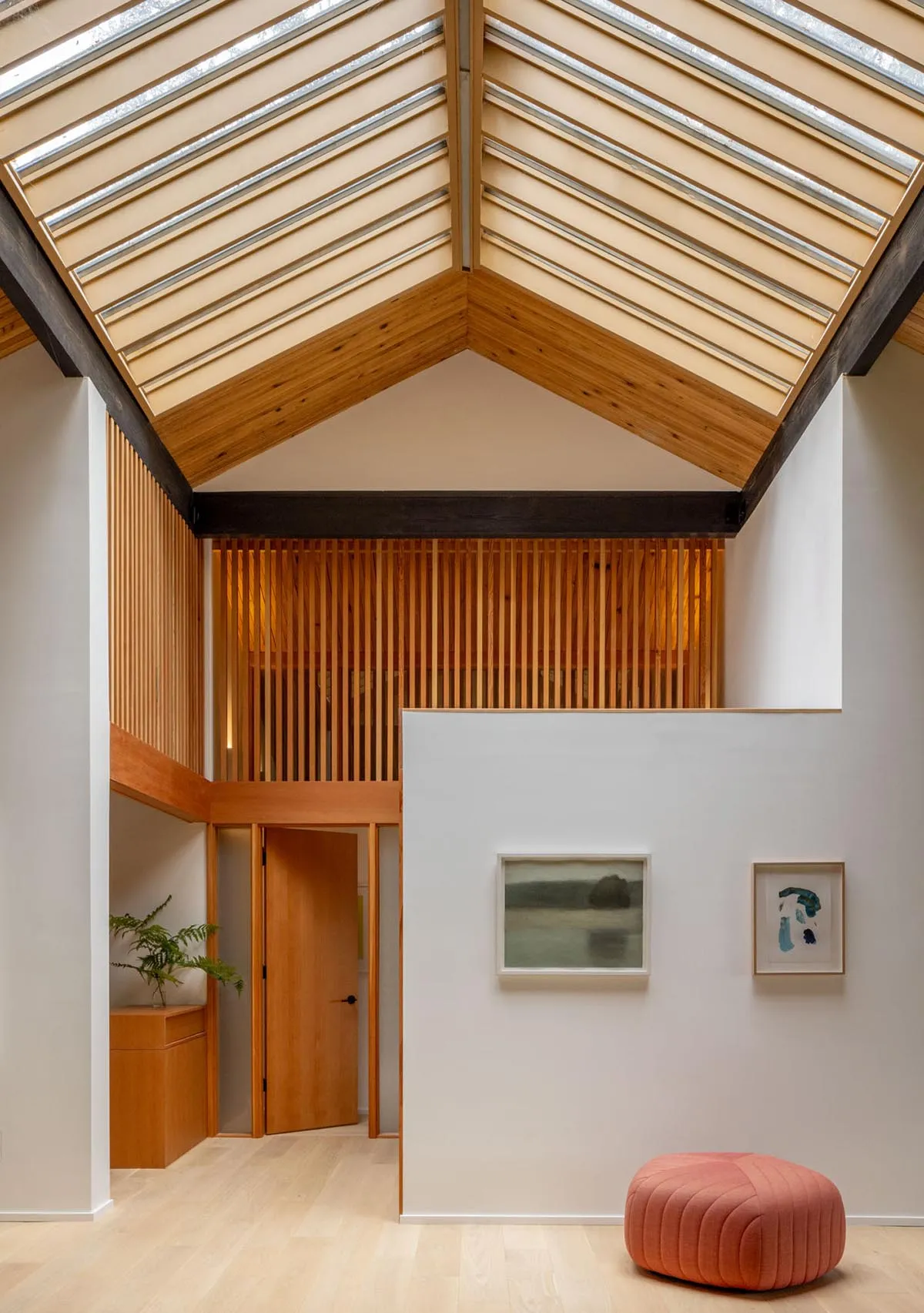 A modern interior space with a wooden ceiling, featuring a contemporary living area with minimalist design elements.