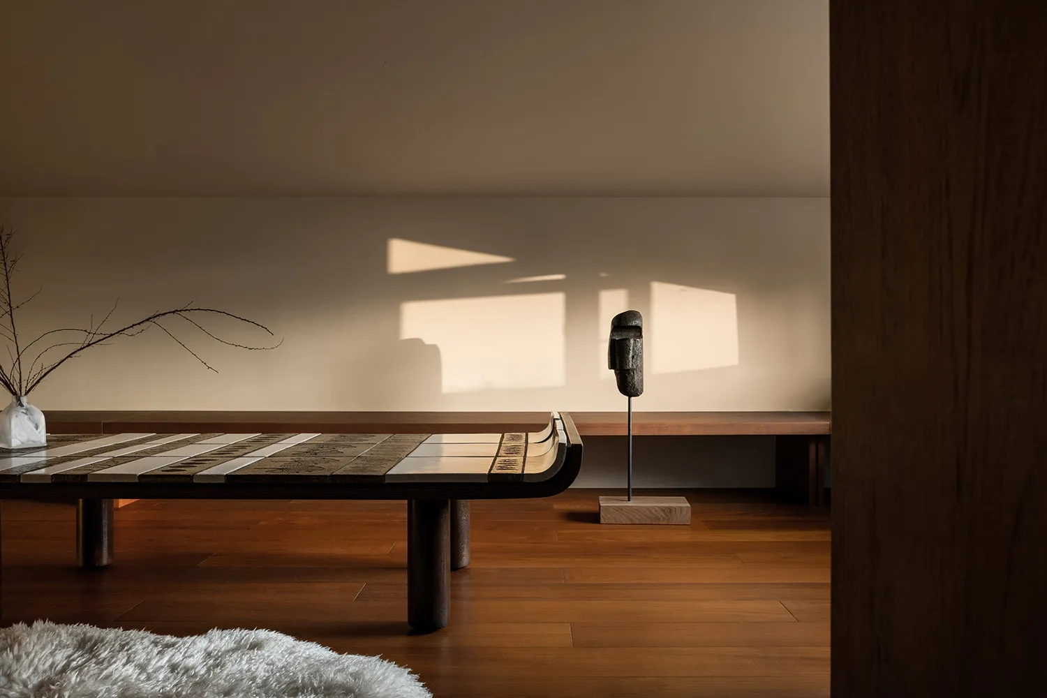 Modern living room featuring wood and marble furniture, with minimalist design elements and natural light.
