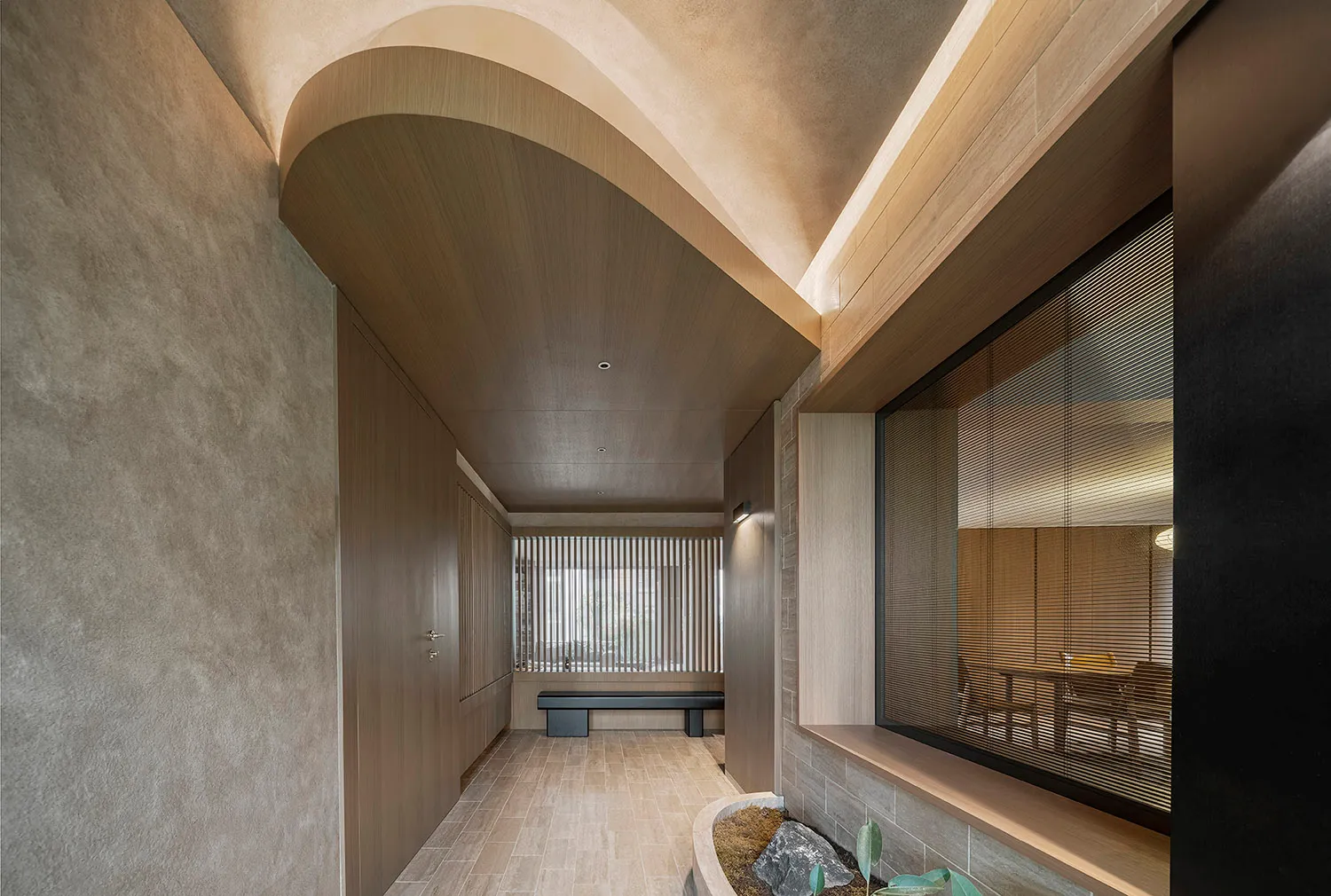 Modern lounge area with wooden seating, concrete walls, and vertical blinds