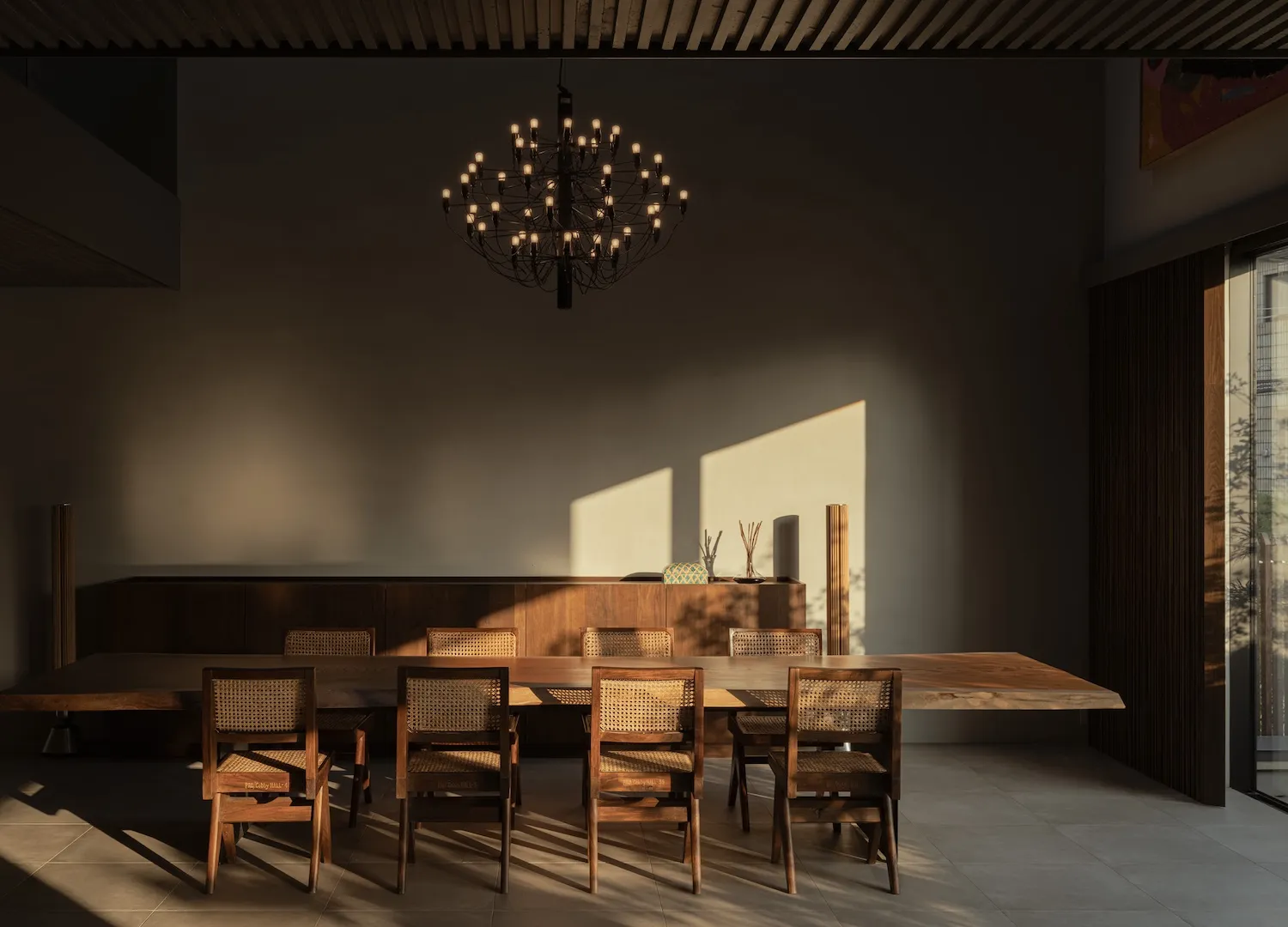 Minimalist dining room featuring wooden furniture with wicker accents.