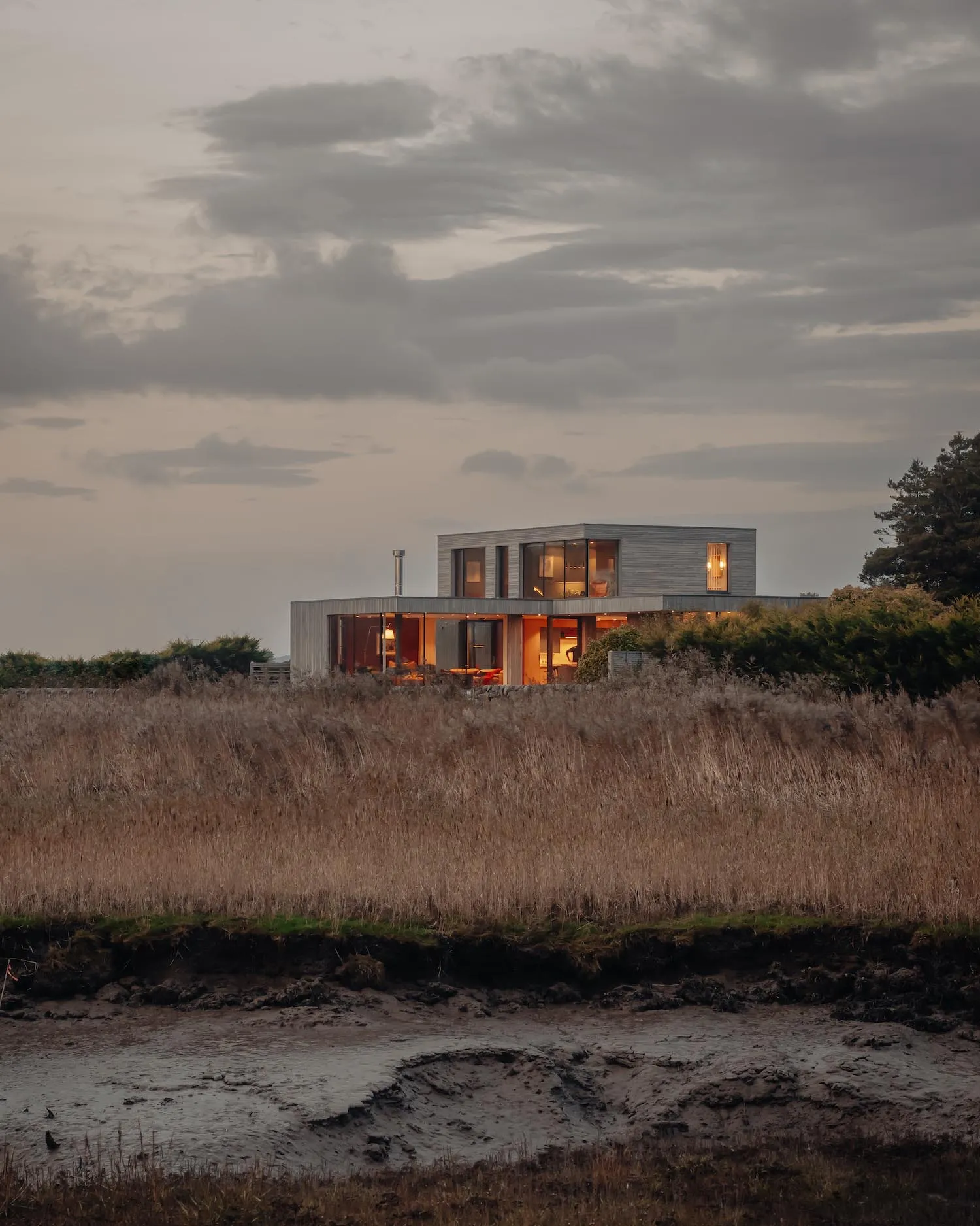 A modern residential house with a wooden exterior and large windows.