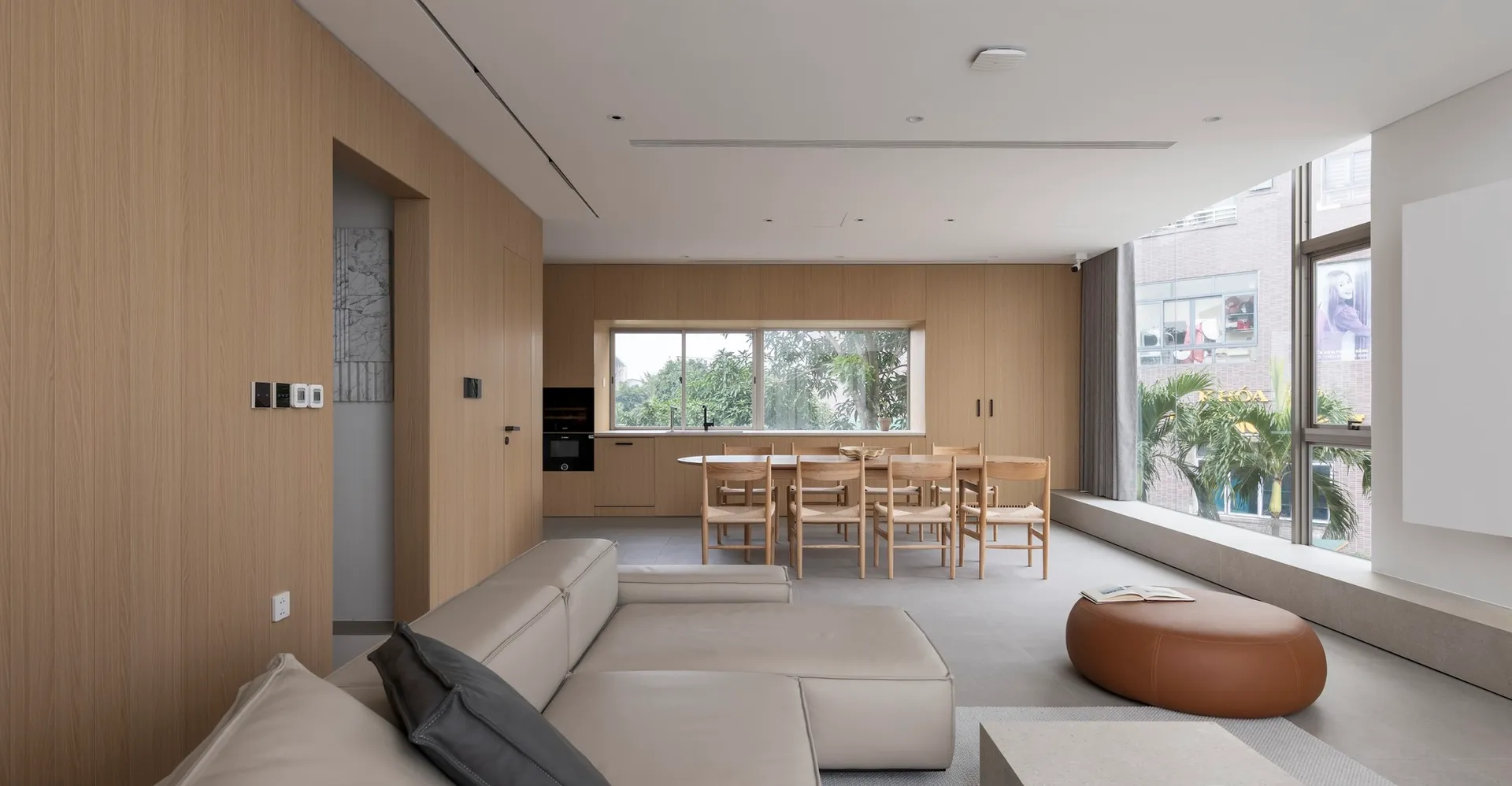 Modern living room, dining area, and kitchen with wooden materials and clean lines.