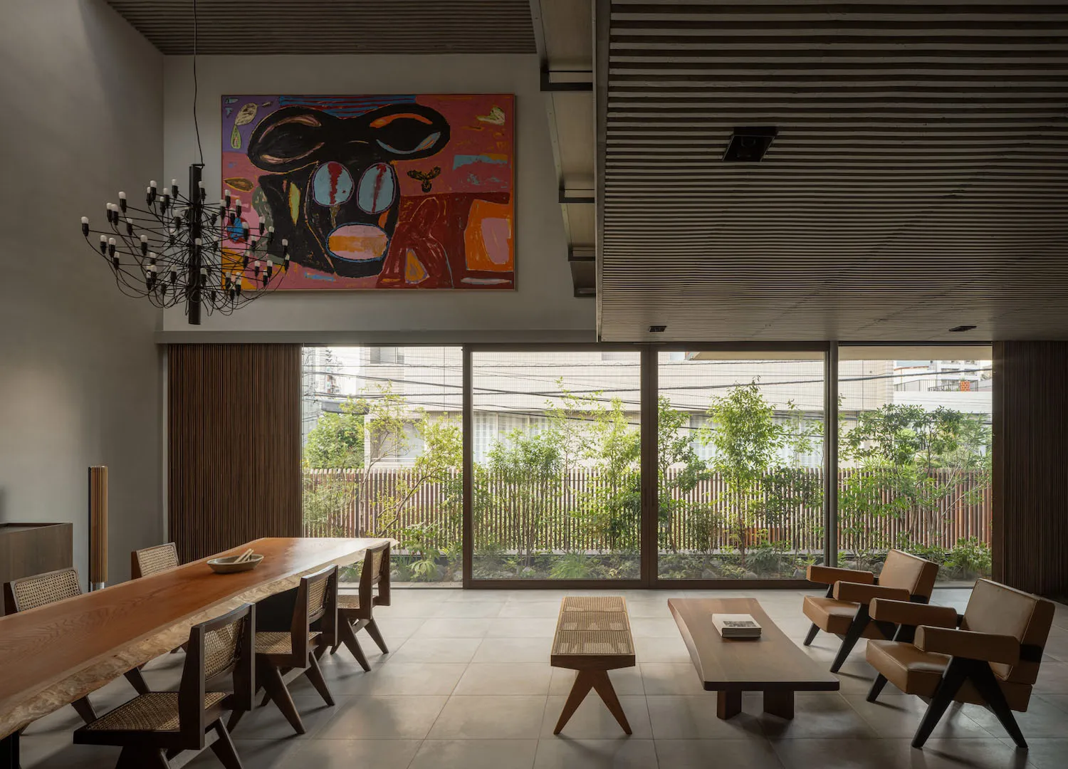 A modern living room with wooden furniture and large windows.