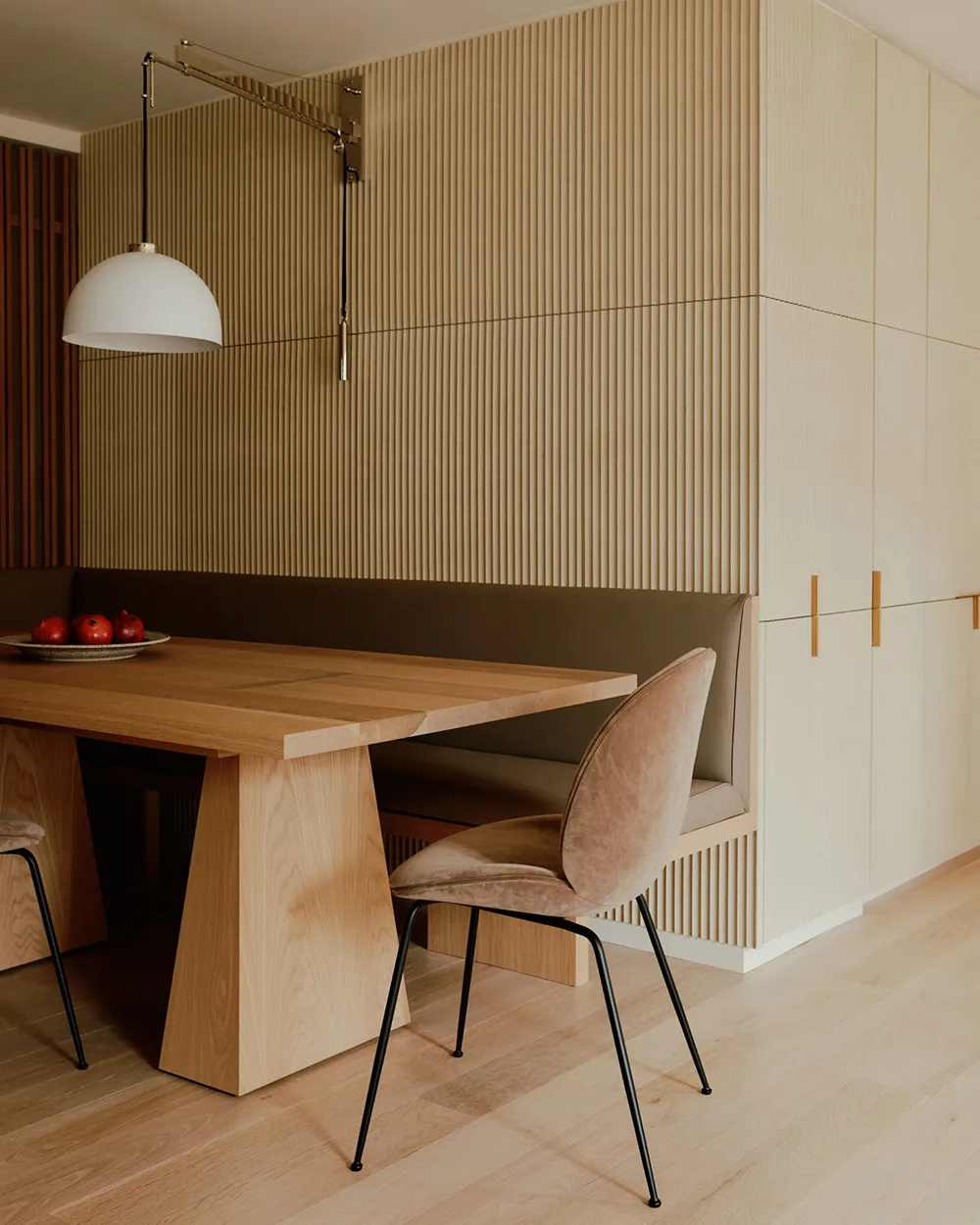 A modern kitchen breakfast nook featuring wooden elements and a bench seat.