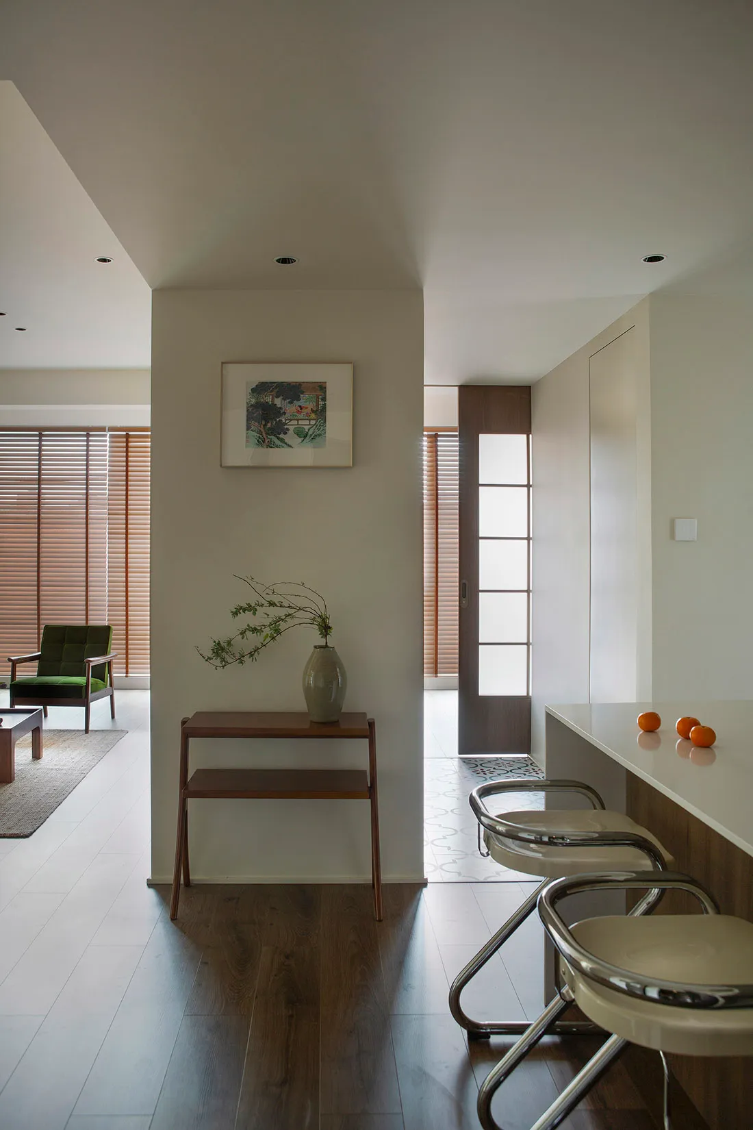 Modern kitchen and dining space featuring a wooden table, glass vases, and minimalist design.