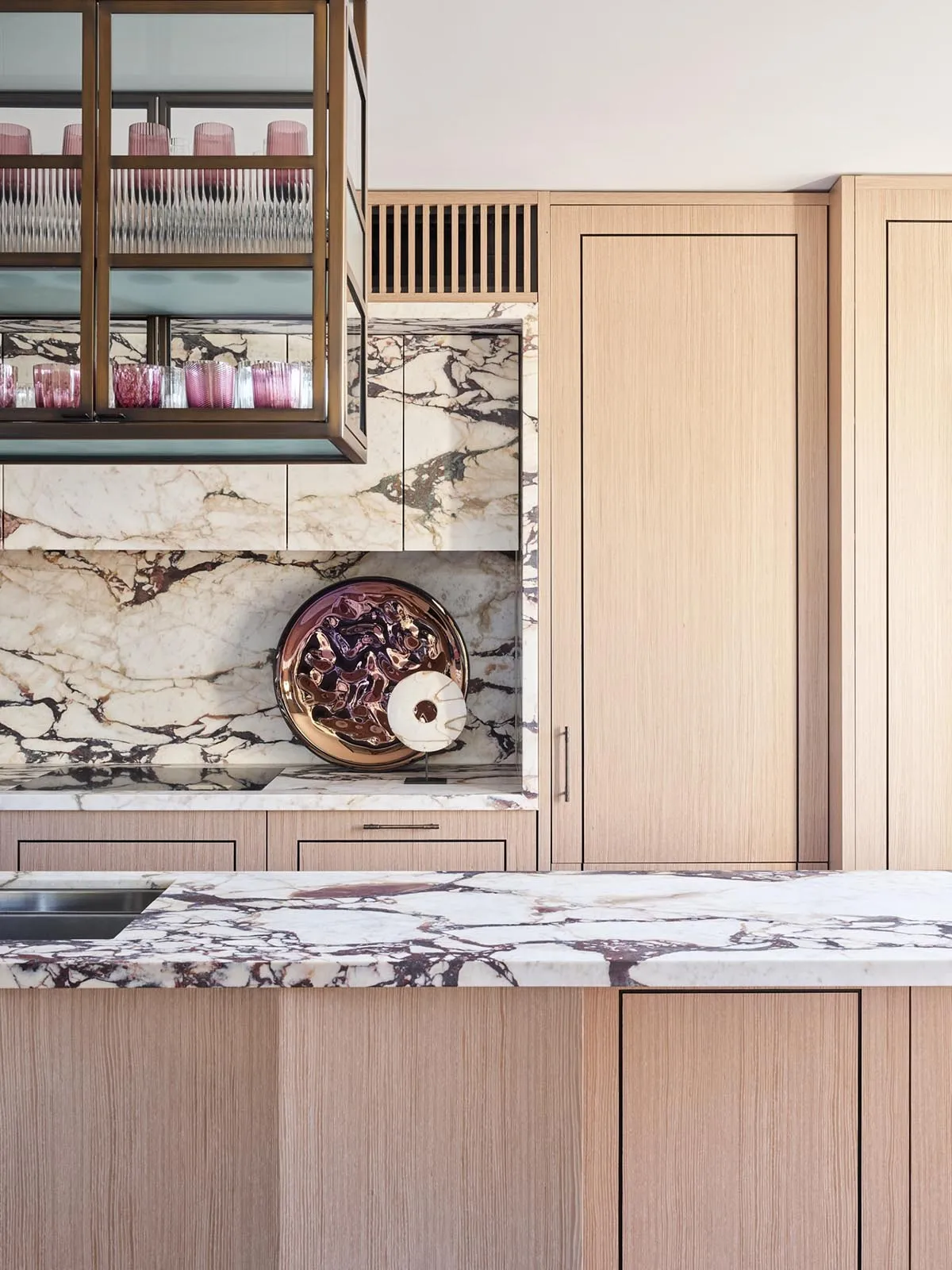 Modern kitchen featuring marble countertops and wooden cabinetry.