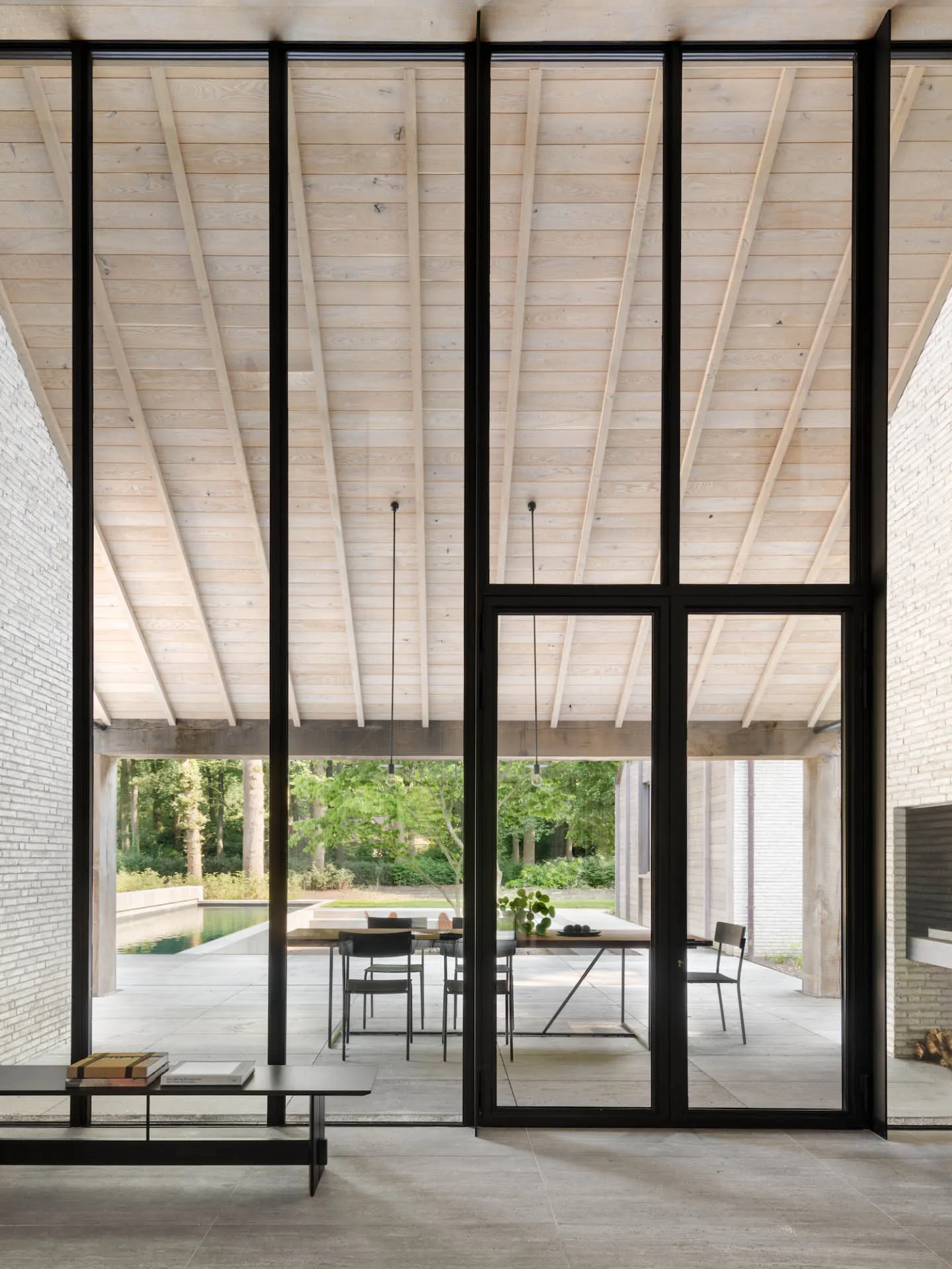 Contemporary indoor living space with modern furniture and large glass windows.