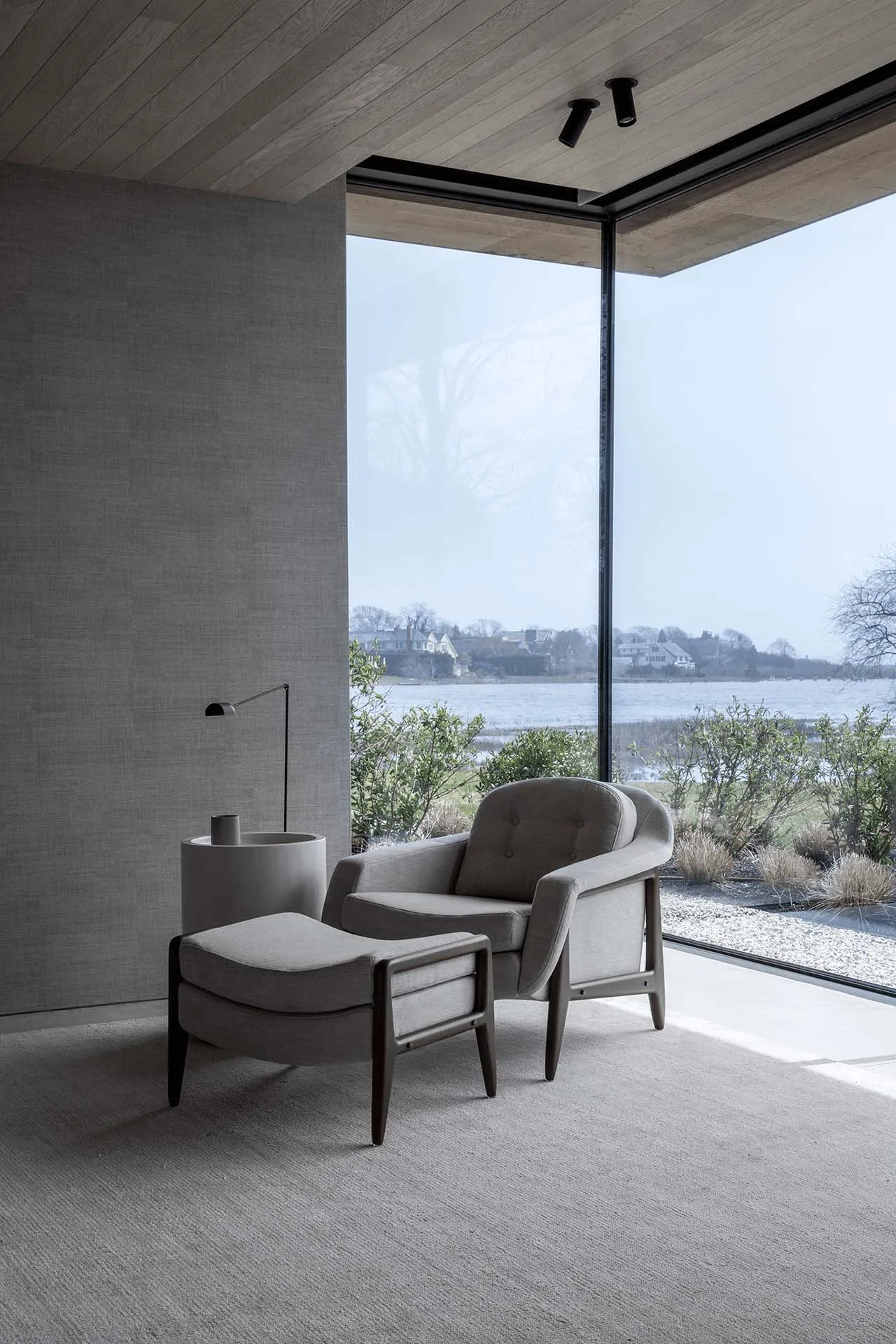 A modern living room with a minimalist design featuring a neutral color palette, featuring comfortable seating and a view of