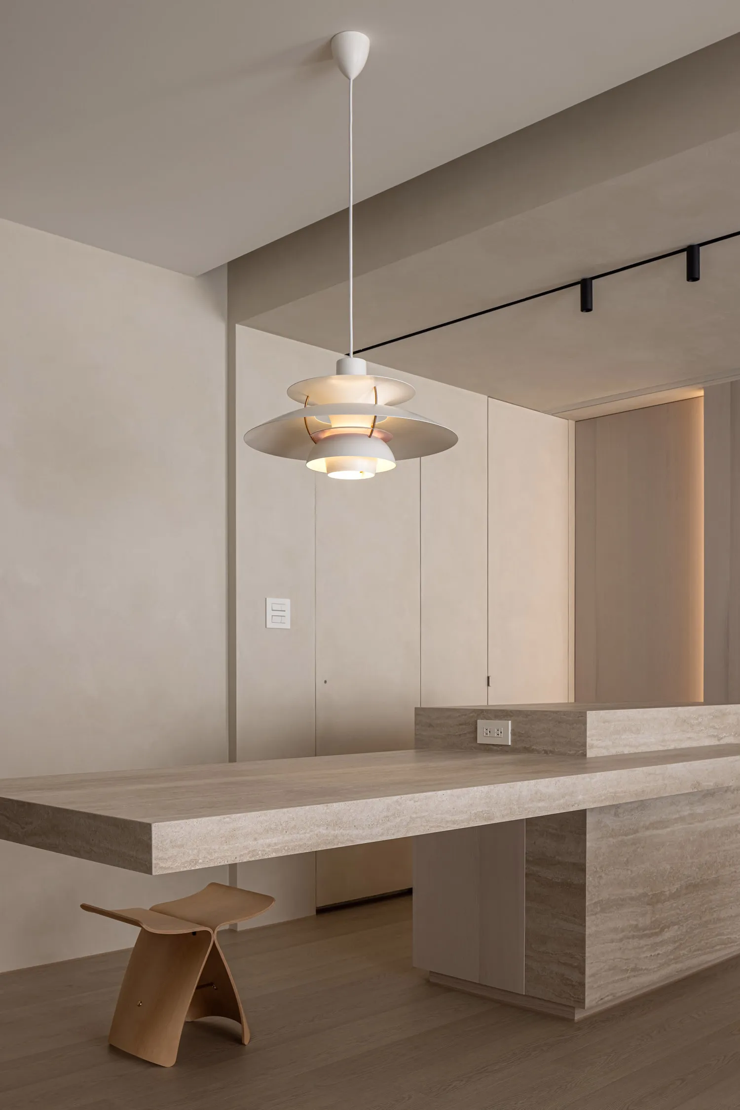 Modern minimalist kitchen featuring a large kitchen island with a concrete countertop and wooden elements.