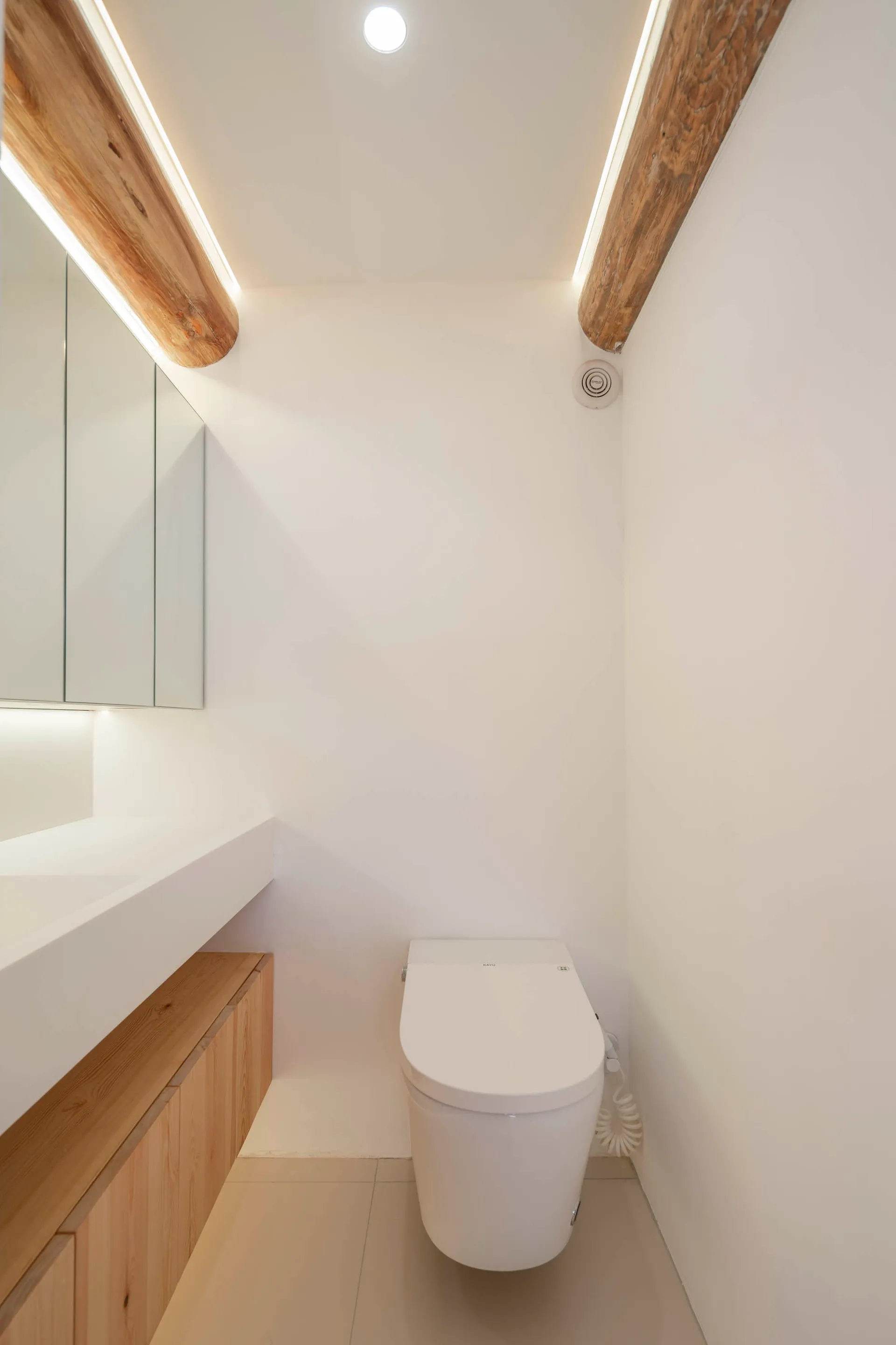 A modern bathroom featuring white wooden finishes and minimalist design.