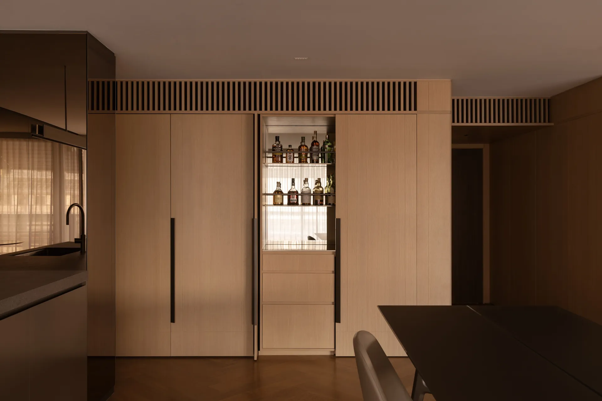Contemporary minimalist kitchen featuring wooden cabinets and a built-in bar.