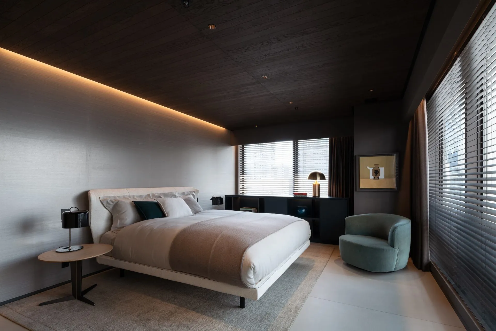 A minimalist bedroom featuring a fabric bed and modern furnishings.