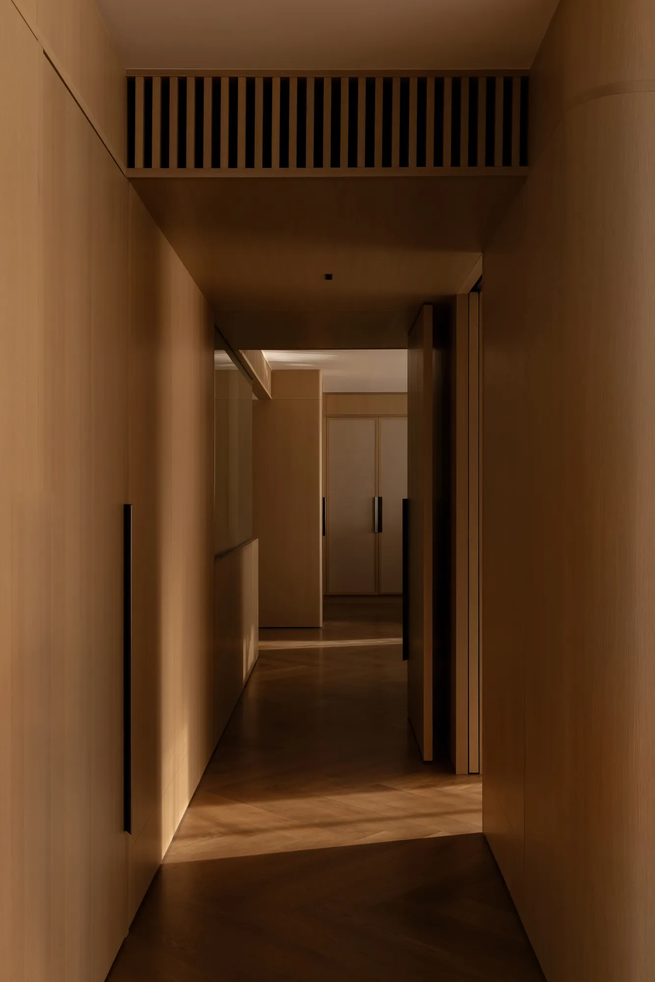 A minimalist corridor with timber walls and a wooden floor.