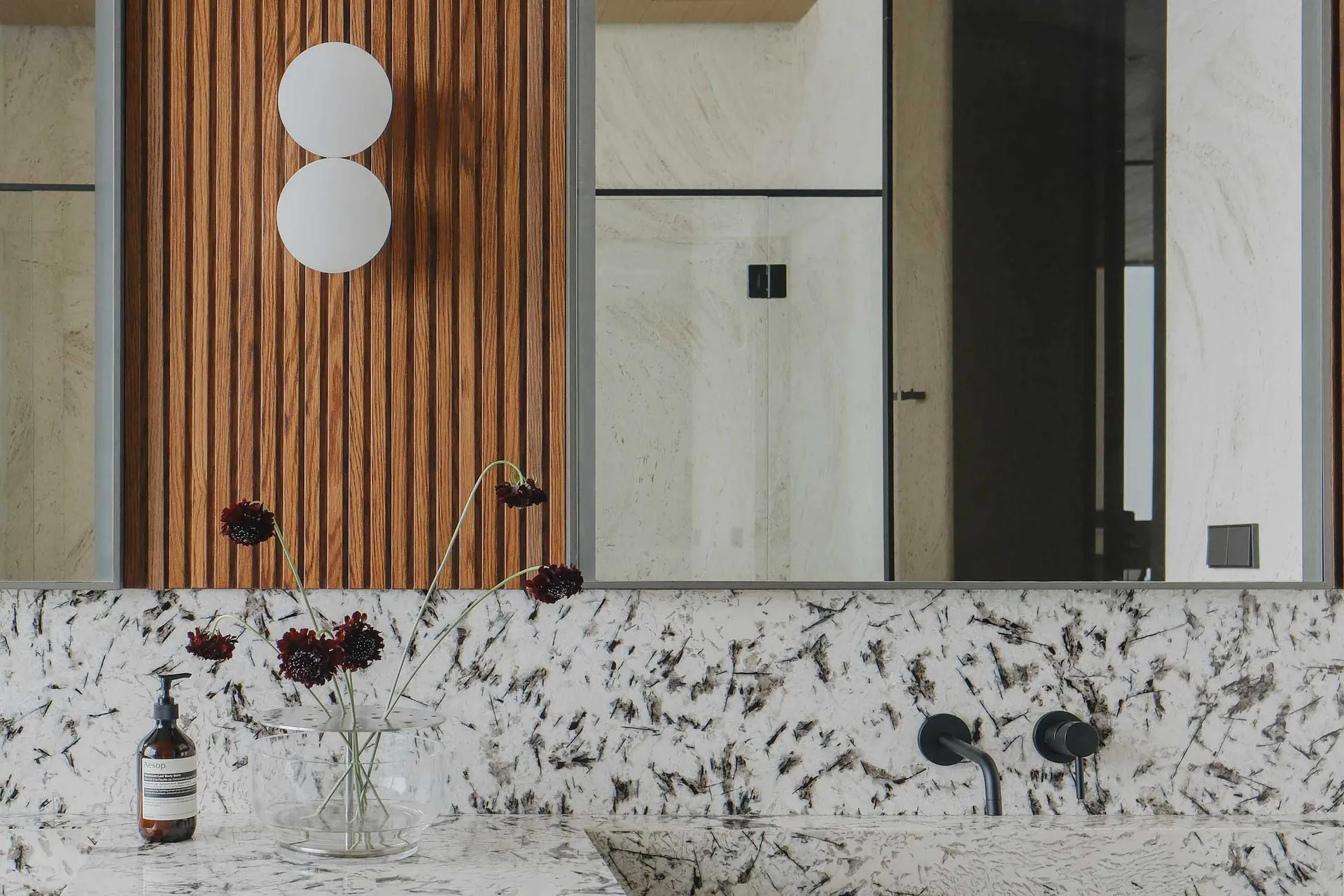Modern bathroom featuring a luxurious granite countertop with a minimalist sink and sleek metallic faucet, illuminated by a c