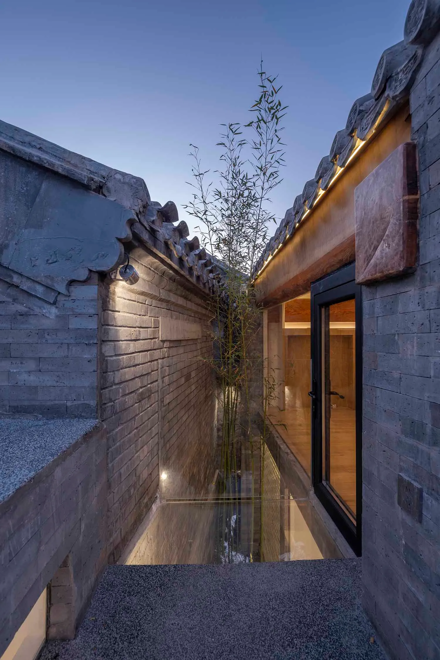 A narrow passage with tiled walls, brick and concrete structures, and traditional Chinese roofing tiles