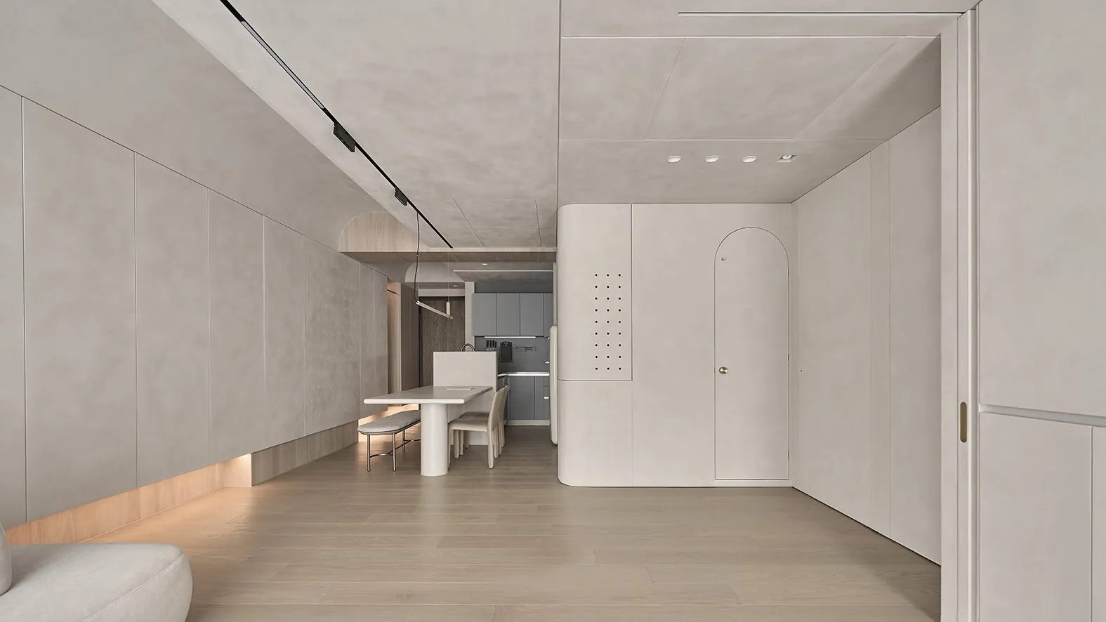 A minimalist kitchen with concrete finishes and a central dining table.