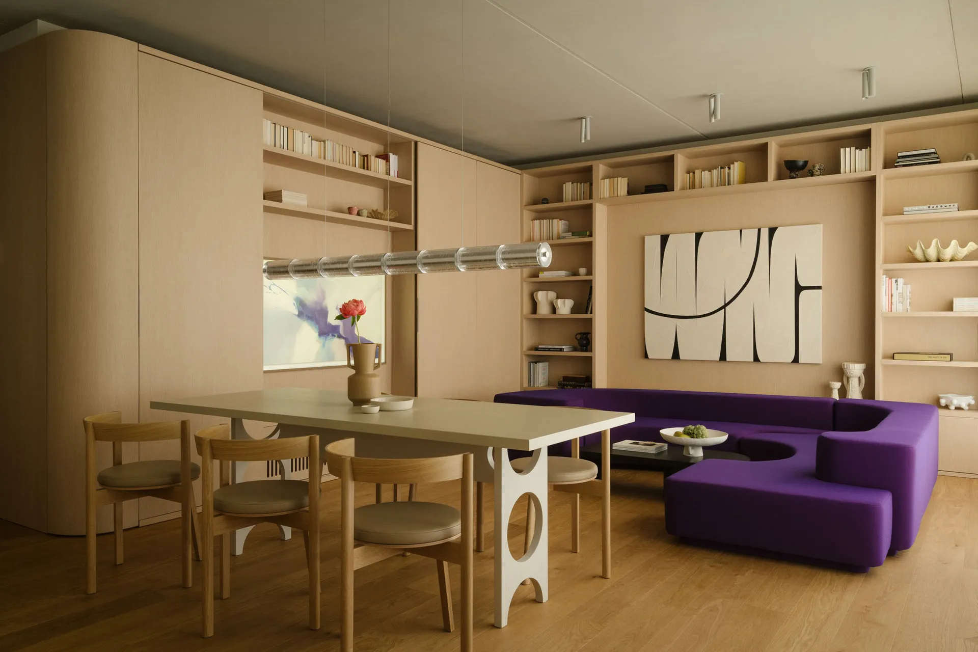 A minimalist living room featuring wooden furniture, bookshelves, and a purple sofa.